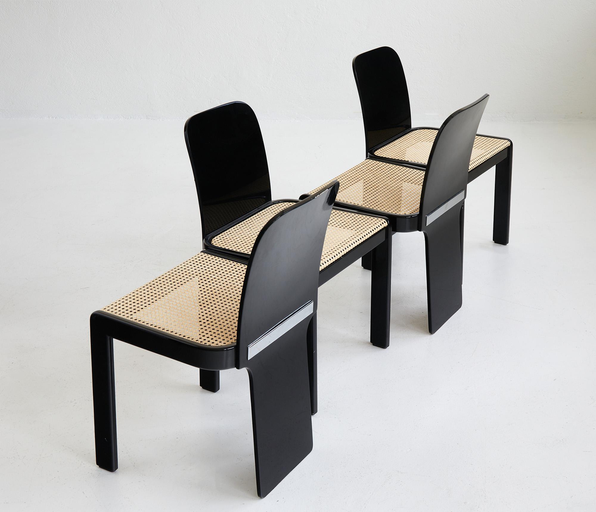 Set of 4 dining chairs by Pierluigi Molinari for Pozzi Italy 1970.

This gorgeous set of dining chairs features an elegant curved structure in glossy black lacquered wood which harmonizes wonderfully with the delicate Vienna cane seat that has been