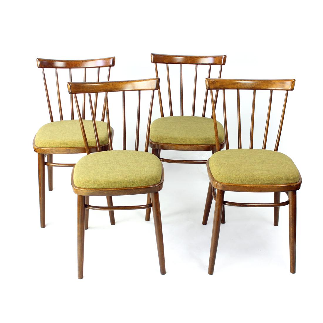 Bellissimo set di quattro sedie da pranzo prodotto dall'azienda Tatra. Etichetta originale ancora visibile sul fondo. Le sedie sono realizzate in una splendida struttura in Oak scuro con schienali eleganti. I sedili sono originali in tessuto