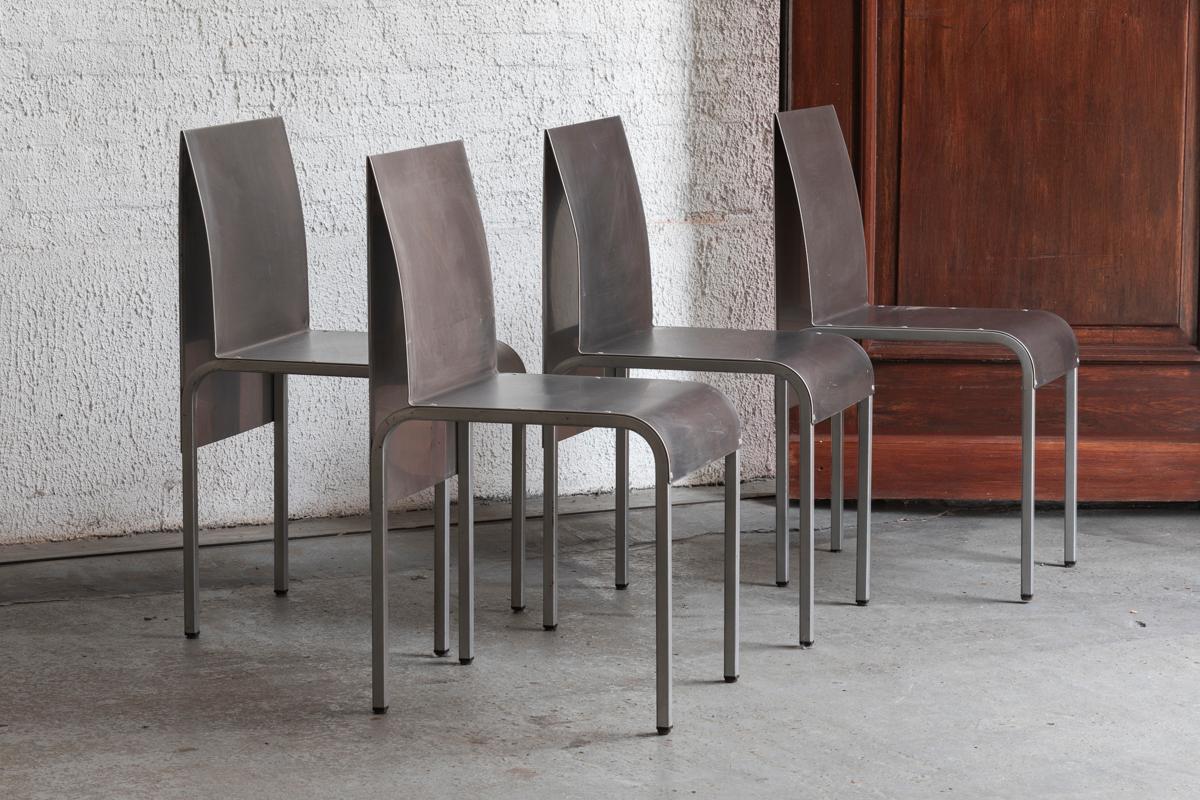 Set of 4 dining chairs in bent aluminum, Belgian design from the 1980’s. The metal plates embrace the bent metal legs. A design with a focus on clear forms. Some wear due to normal use, overall in good condition.

H: 82 cm
W: 39 cm
D: 46 cm
Seat