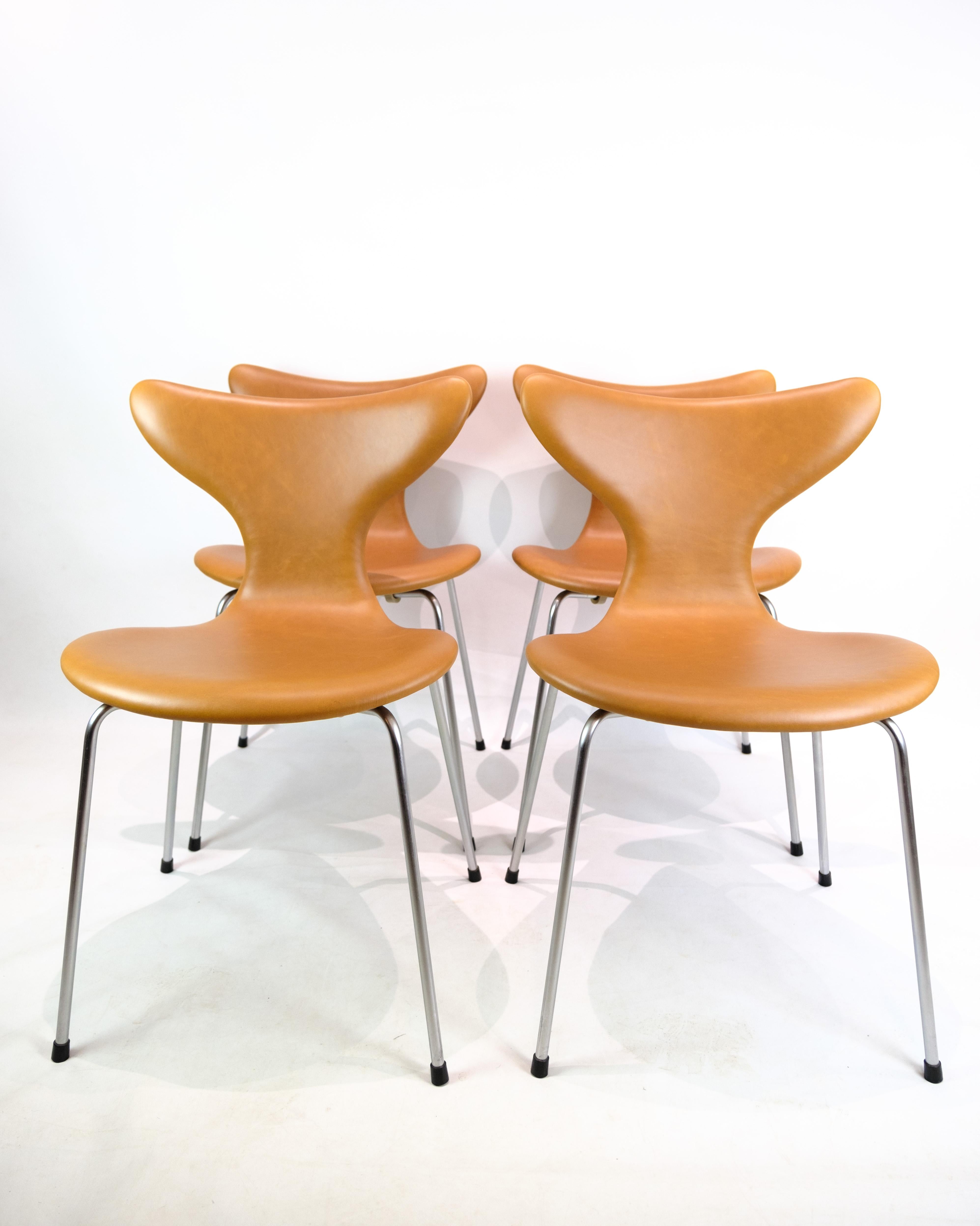 Ensemble de 4 chaises de salle à manger, modèle 3108 Lilje/Mågen, conçu par Arne Jacobsen et produit par Fritz Hansen dans les années 1970. Les chaises sont fabriquées dans un design élégant avec du bois moulé et souple, recouvert de cuir Cognac
