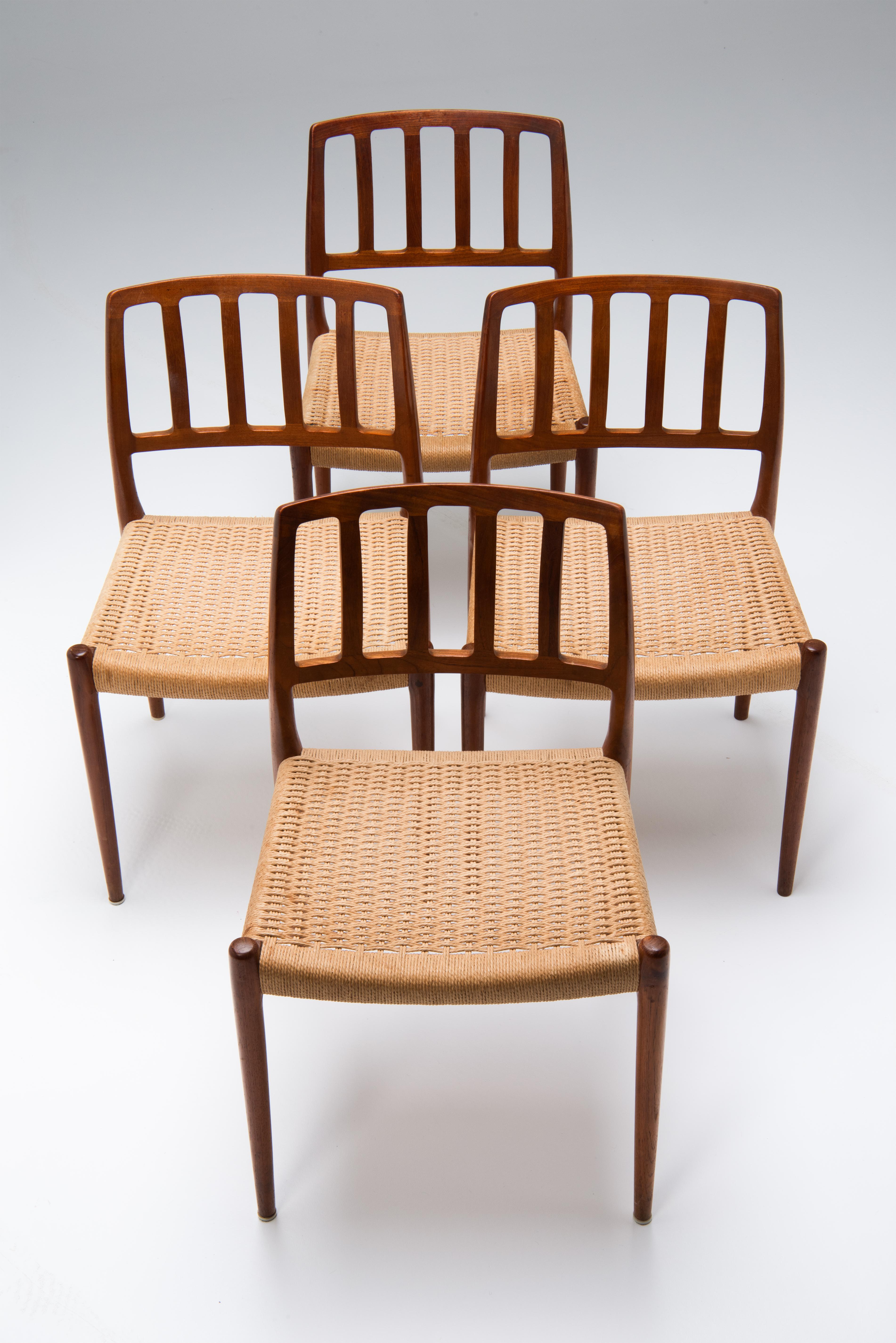 Un ensemble de 4 chaises de salle à manger Modèle 83 en teck, conçu en 1974 par Niels O. Møller pour I.L.Møller au Danemark. 
Le cordon de papier est d'origine et est encore en bon état. Il présente quelques taches et une différence de couleur comme