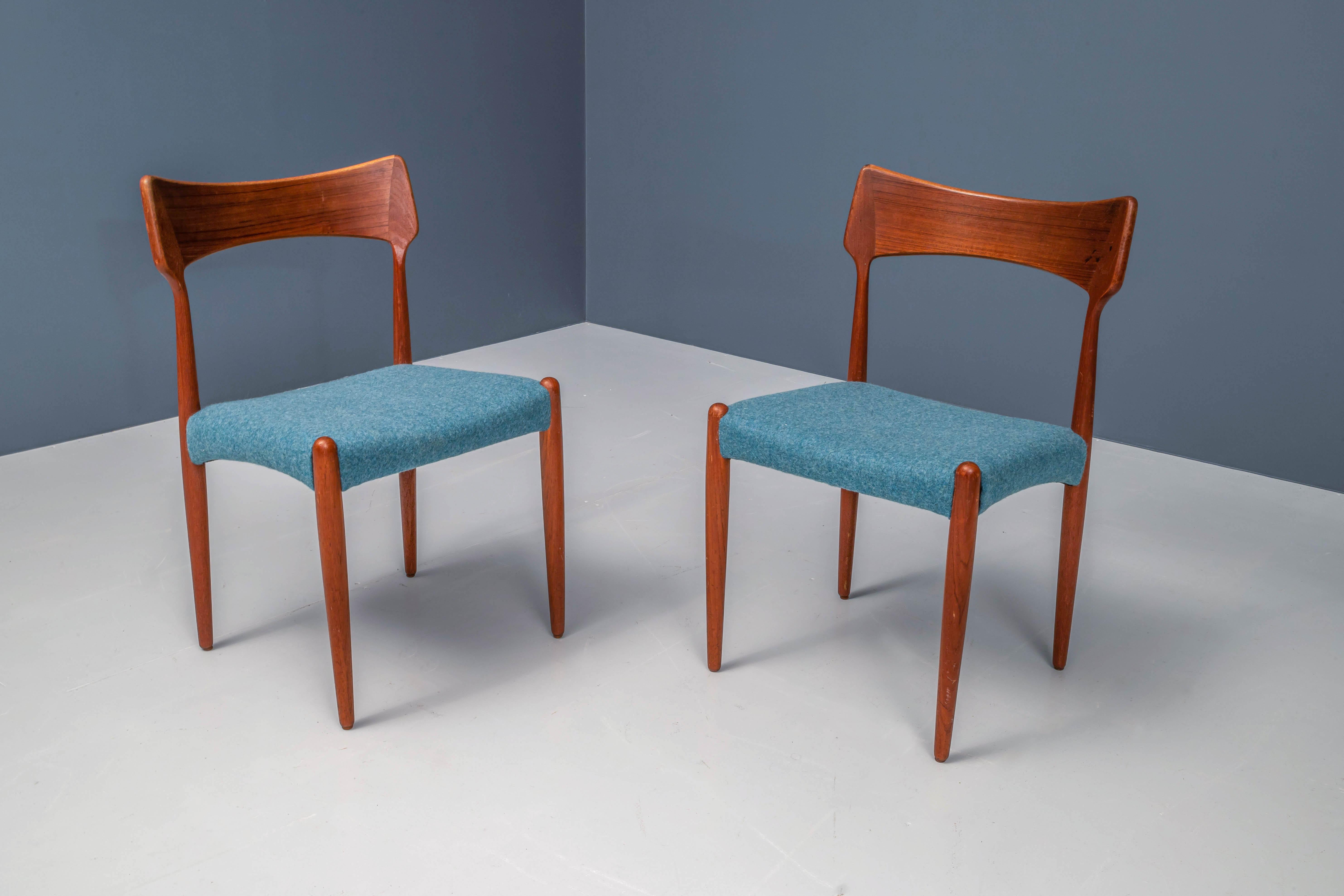Vous recherchez des éléments danois frais et vifs dans votre maison ? Un ensemble de 4 chaises en teck nouvellement tapissées de laine bleu pétrole qui forme un bon contraste avec le bois brun très chaud. De grandes formes dans le dossier qui
