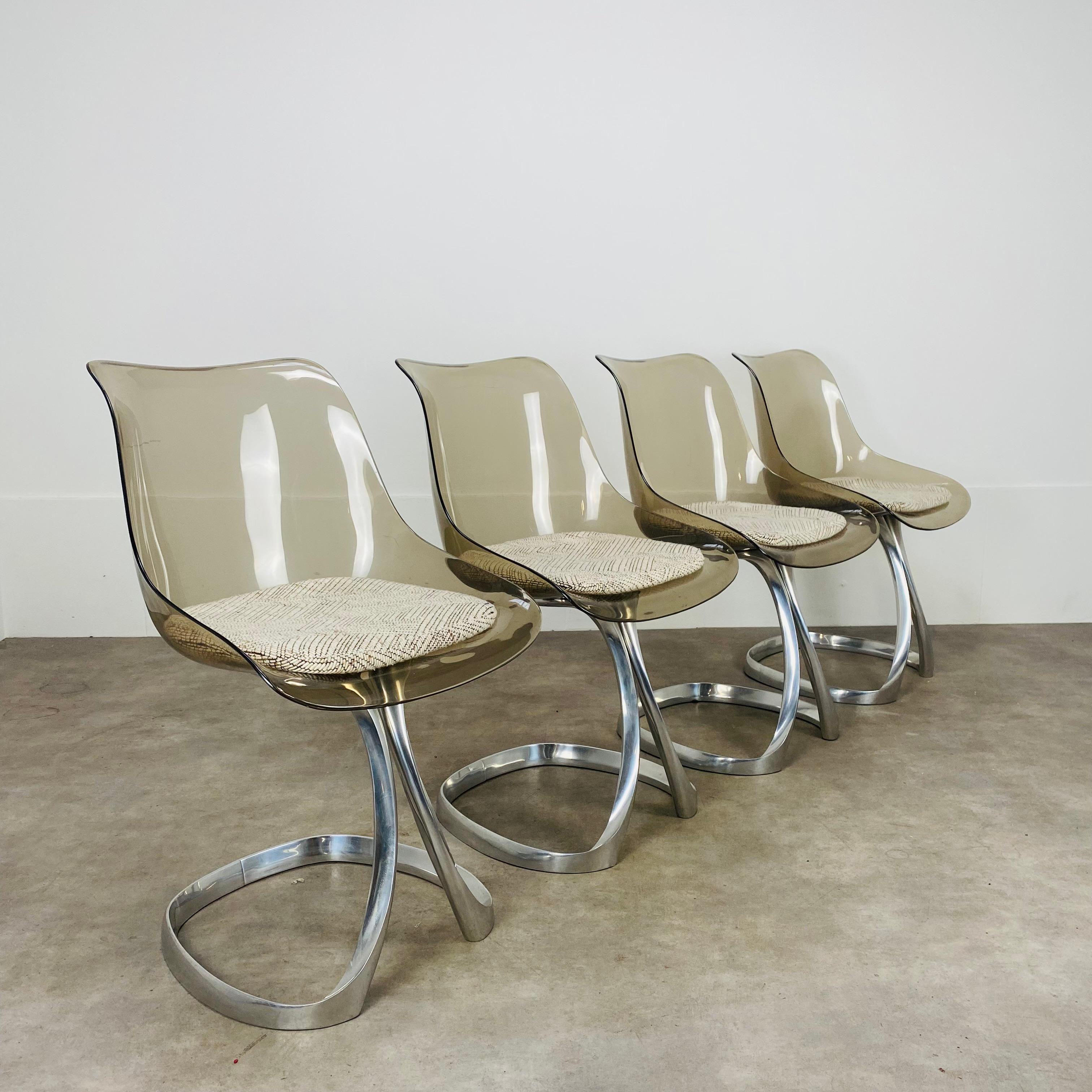Set di quattro sedie da pranzo del designer francese Michele Charron, dal design tipico degli anni Settanta. 
Condizioni molto buone, rari segni di usura sul plexiglass e sulle basi delle sedie in alluminio. I cuscini originali in tessuto sono
