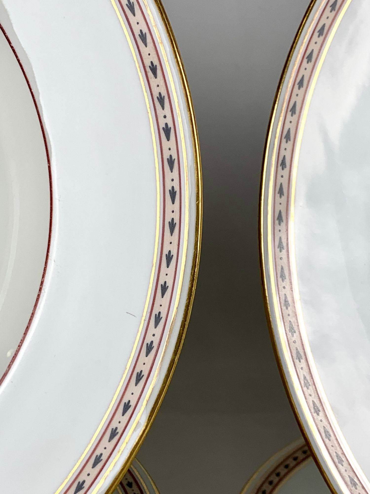This lovely set of hand painted 18th-century Imperial Vienna Porcelain dishes features four dinner dishes, four soup/pasta dishes,
and a pair of chargers for serving.
The decoration is elegant.
Along the edge, we see a band of black darts and dots