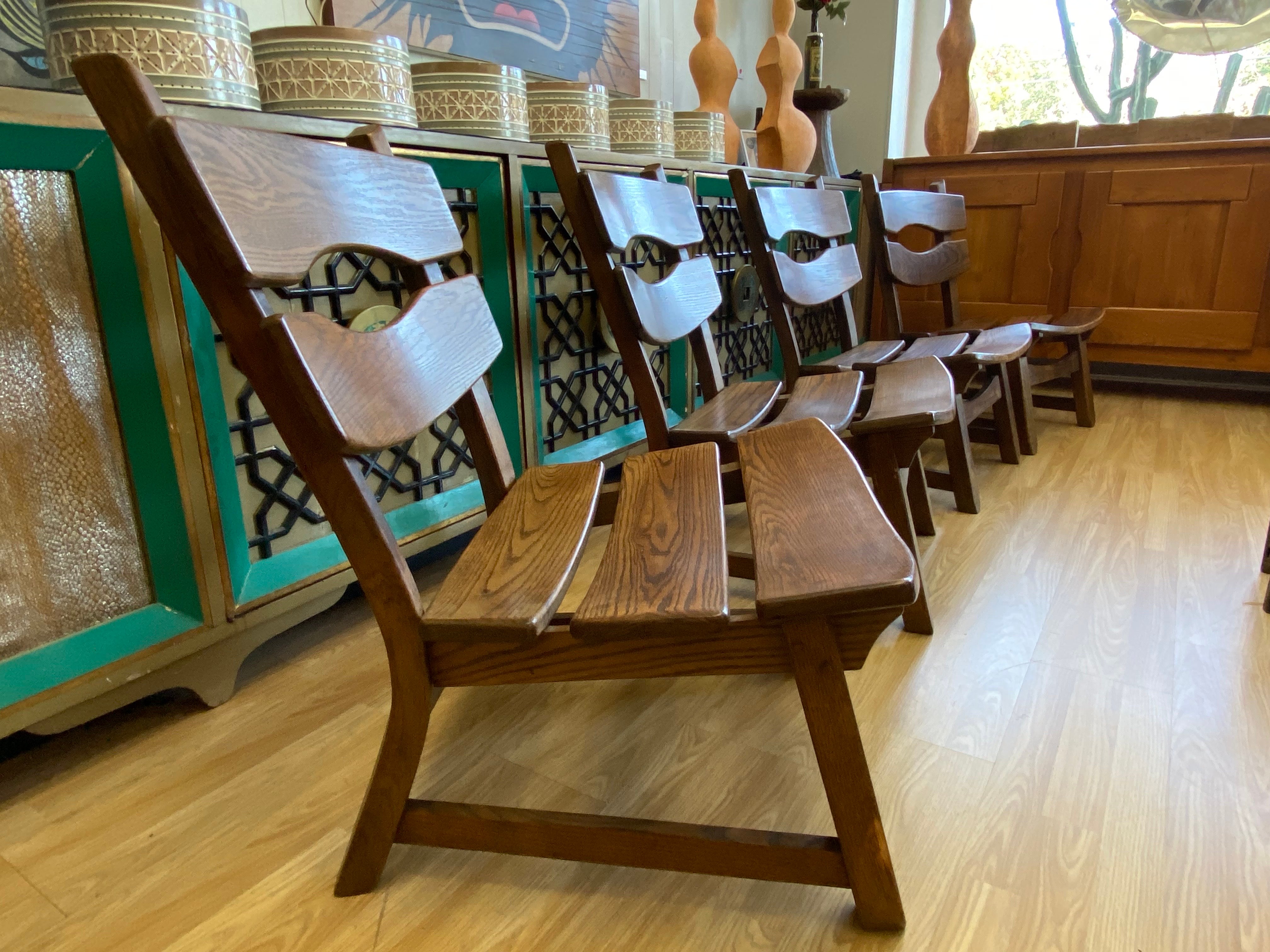 Set of 4 Dittmann & Co for AWA Holland brutalist fireplace lounge chairs circa 1960s, Netherlands. Four dark stained solid oak armless lounge chairs feature a rounded slatted back and seats. They are sold as four, please inquire about buying as a