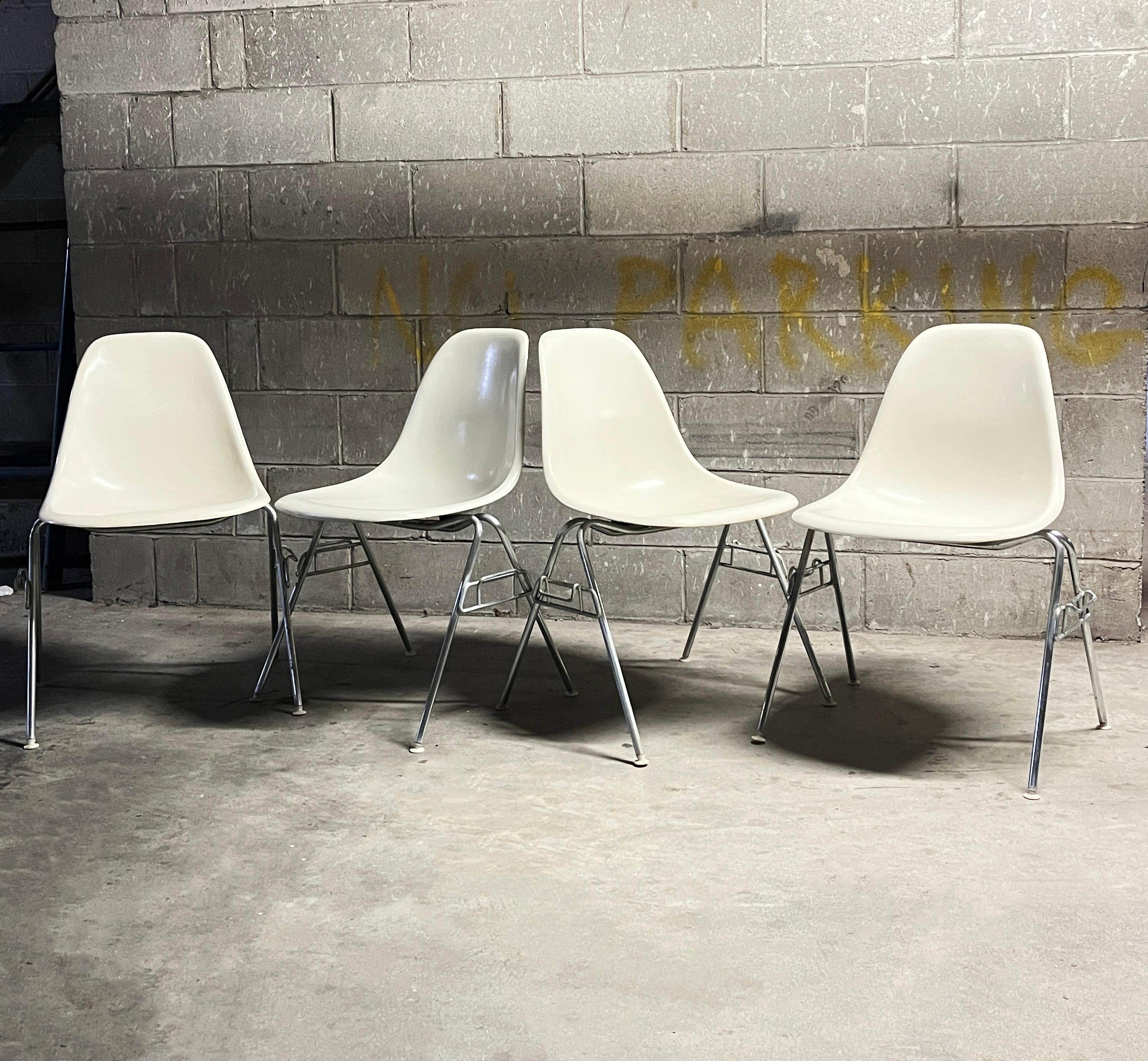 Lot de 4 chaises Eames pour Herman Miller en fibre de verre DSS blanc années 50 (Signé avec le logo Herman Miller sur le bas). Les chaises présentent des traces d'utilisation comme quelques rayures sur les coques. Les chaises sont très robustes et