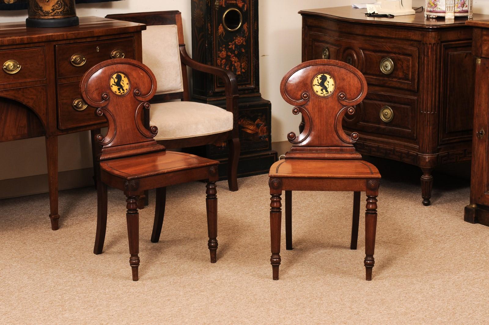 Ensemble de 4 chaises de salle en acajou anglais du début du 19e siècle avec des détails en forme d'écusson de lion. PRIX PAR PAIRE.