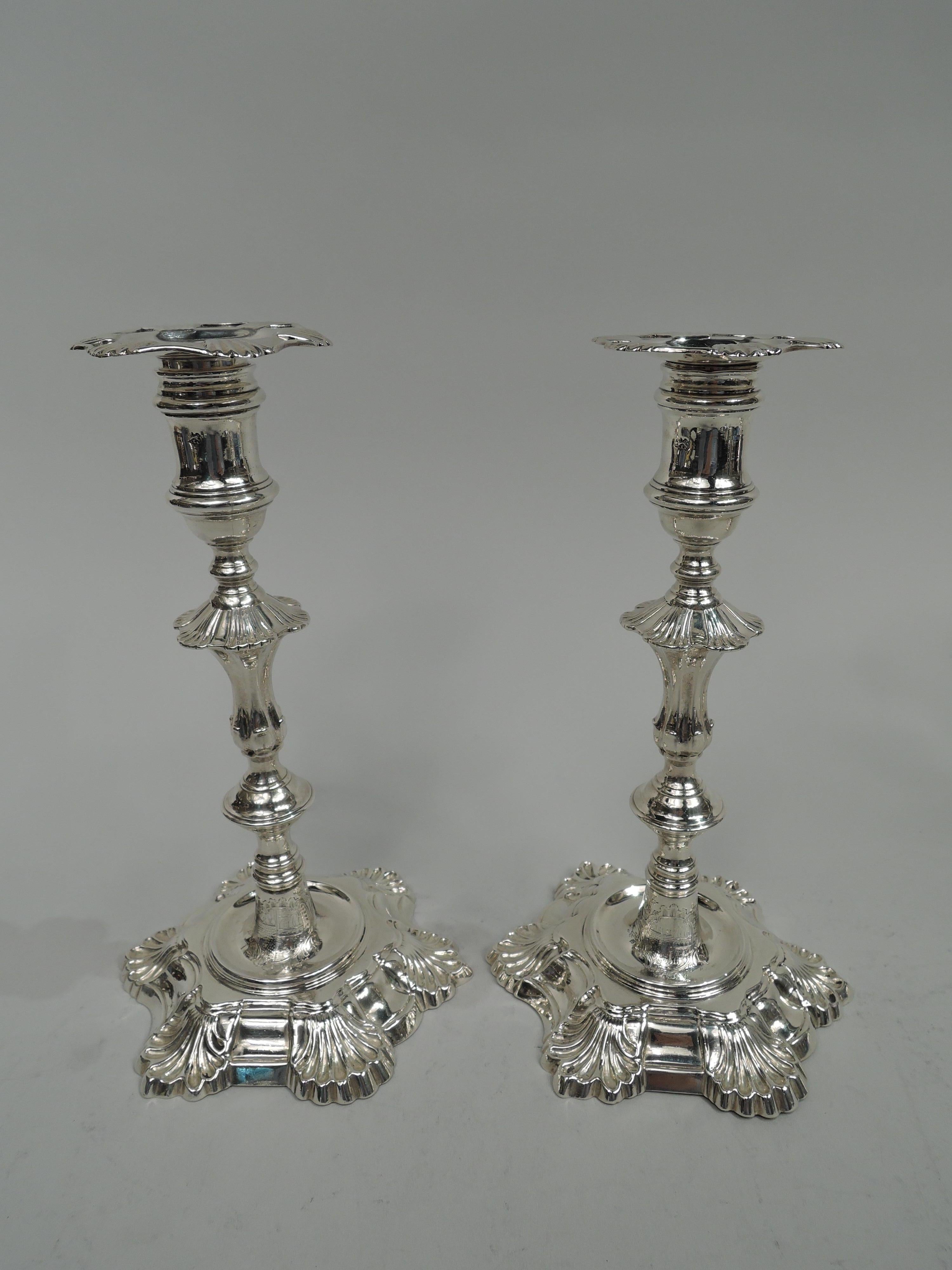 Set of 4 George II cast sterling silver candlesticks. Made by James Morison in London in 1756. Each: Spool socket with detachable bobeche and round bowl on knopped and flanged half-fluted shaft; raised foot on curvilinear six-shell base with