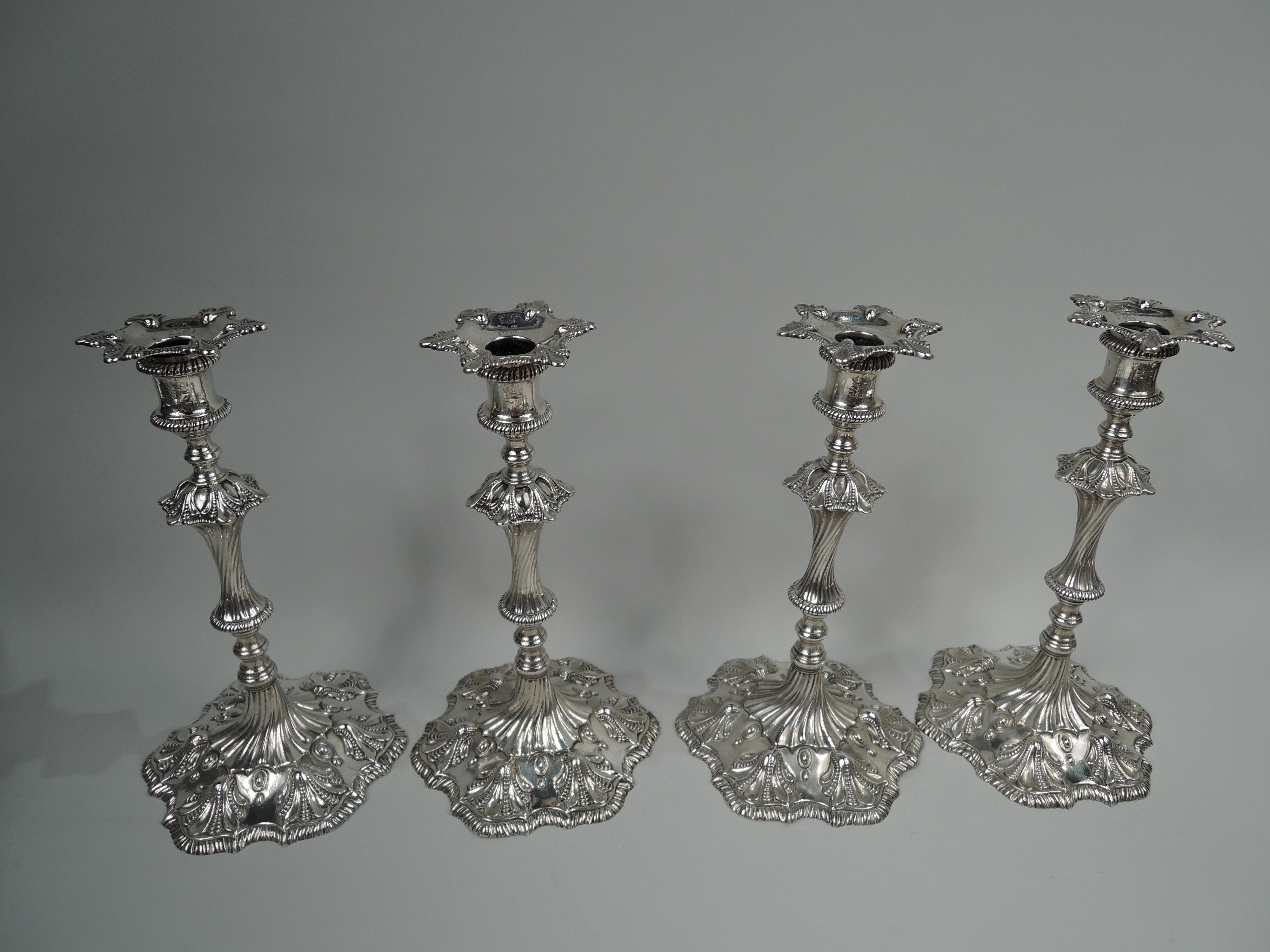 Set of 4 George III cast sterling silver candlesticks. Made by Richard Morson & Benjamin Stephenson in London in 1771. Each: Spool socket with detachable bobeche mounted to knopped and twisted shaft on raised and serpentine foot. Fluted and