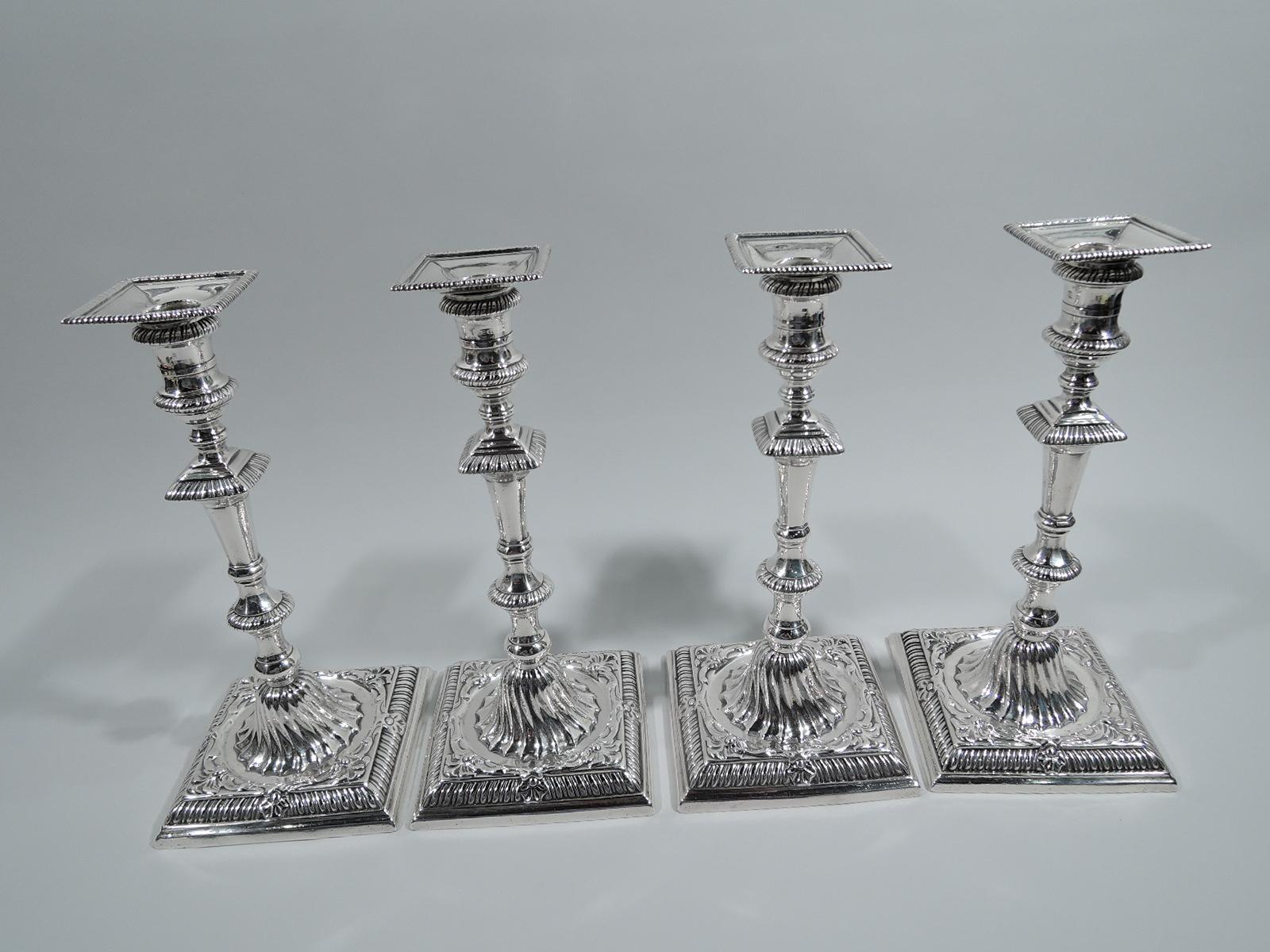 Set of 4 George III sterling silver candlesticks. Made by Ebenezer Coker in London in 1762. Each: Faceted and knopped shaft on domed and twisted-fluted foot mounted to circle set in square foot. Spool socket with detachable square bobeche.