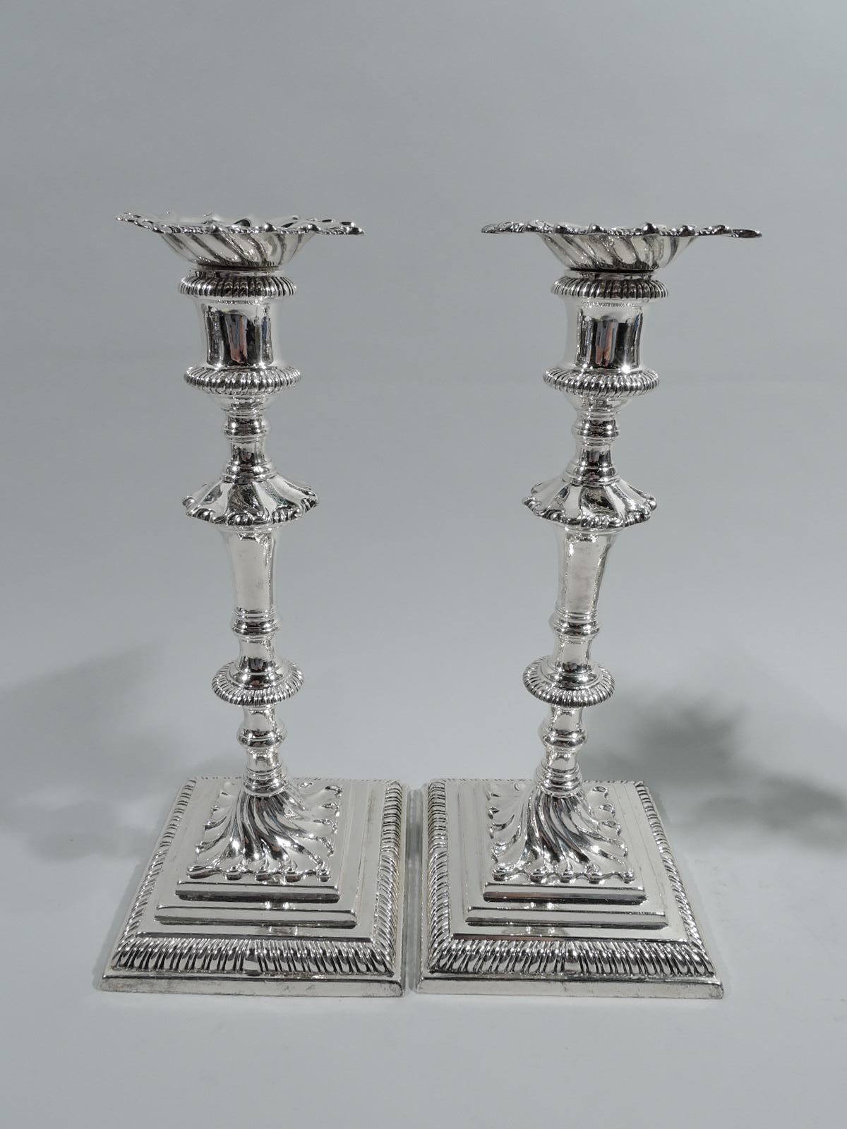 Set of 4 English sterling silver candlesticks, 1768. Each: Spool socket with detachable and twisted-fluted bobeche; tapering shaft with knops and flanges on twisted fluted foot mounted to square and stepped base. Gadrooning. Real deal midcentury