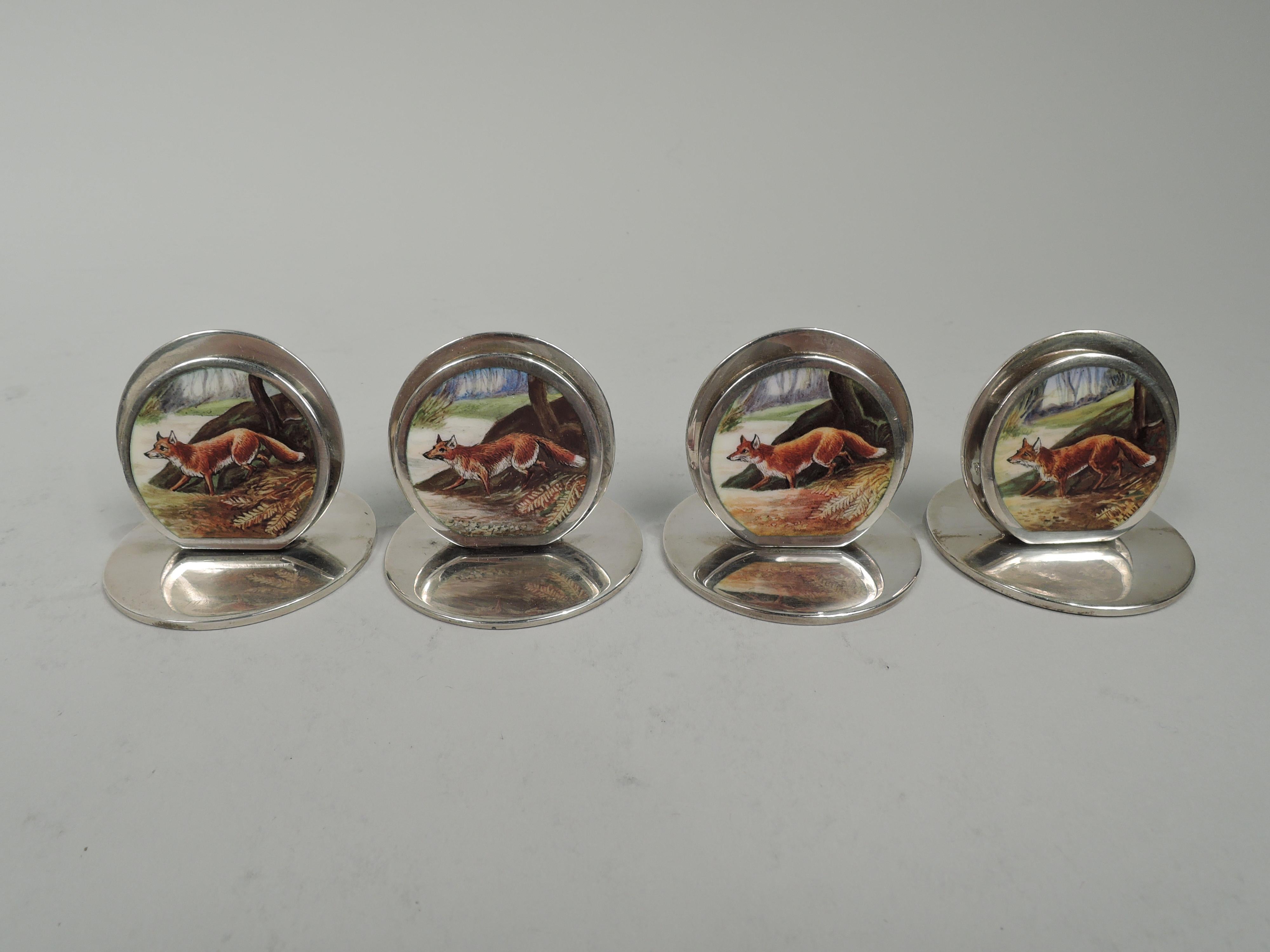 Set di 4 segnaposto edoardiani in argento sterling. Prodotto da Sampson Mordan & Co. Ltd. a Chester, nel 1904-6. Ciascuno: Due dischi piatti montati su una base piatta e circolare. Disco anteriore più piccolo e smaltato con una volpe che si aggira