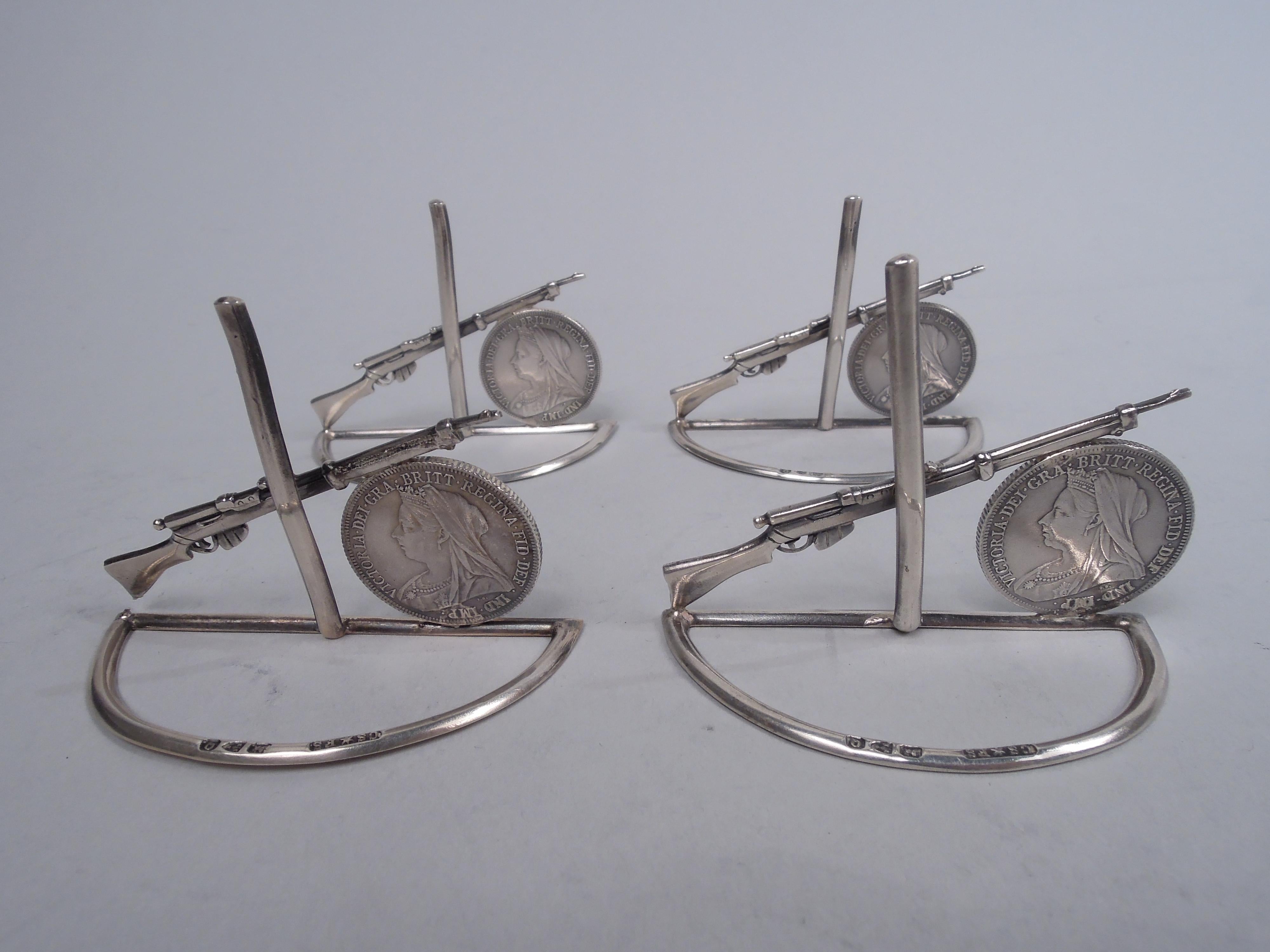 Set of 4 Victorian sterling silver place card holders. Made by Saunders and Shepherd in Chester in 1899. Each: A rifle is propped against a shilling coin dated 1899, the year war broke out in South Africa between the British and Dutch colonial