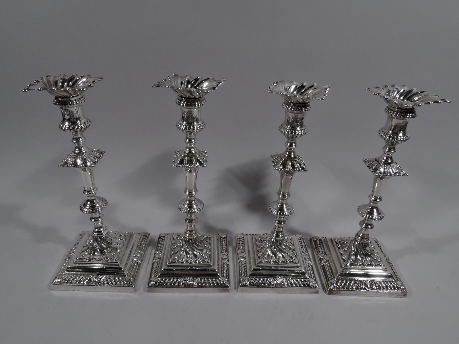 Set of 4 George III sterling silver candlesticks. Made by Ebenezer Coker in London in 1763. Each: Baluster and spool Shafter with beaded flange and gadrooned knop on beaded and twisted foot mounted to stepped square base. Base has dense beaded rows