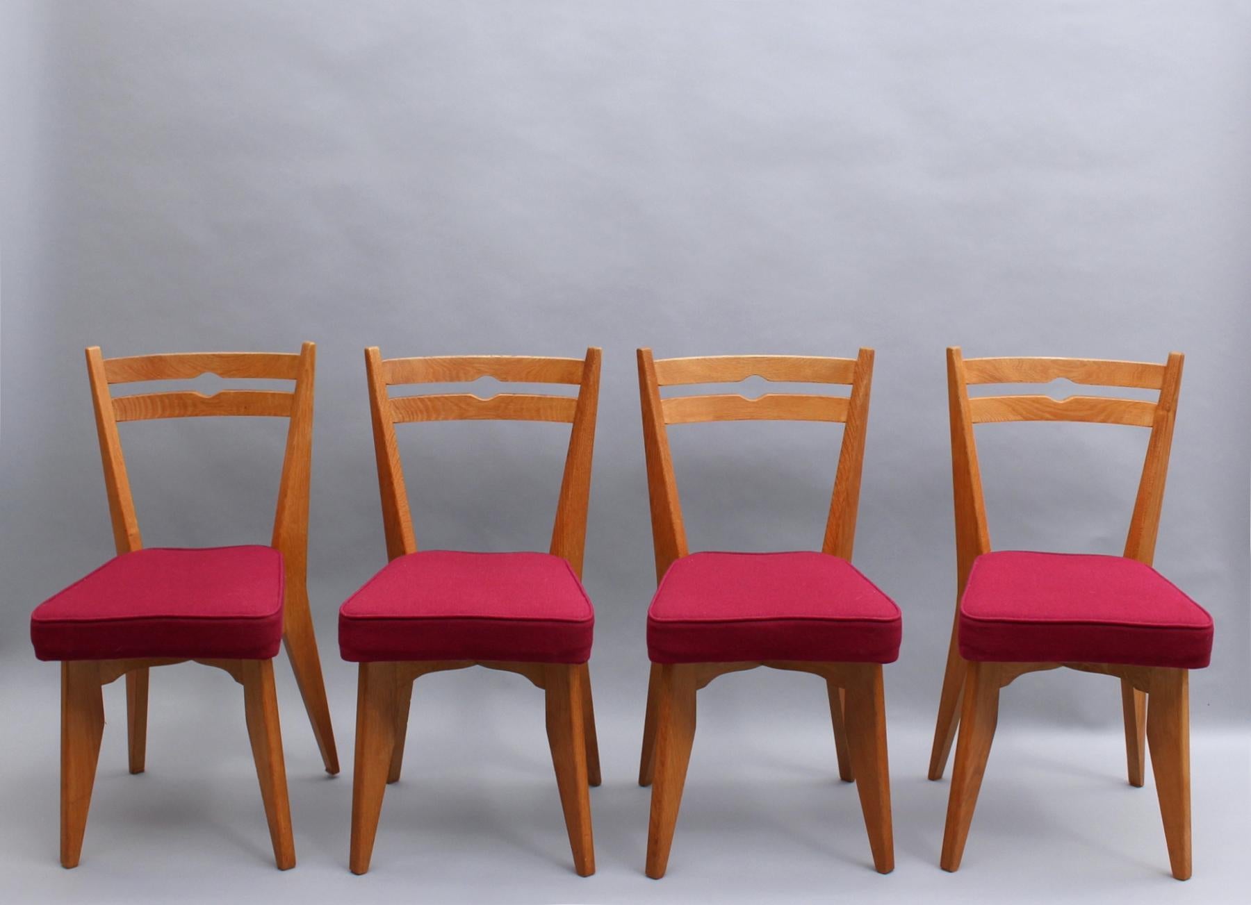 Un ensemble de quatre chaises de salle à manger en chêne massif du milieu du siècle dernier par Guillerme et Chambron pour Votre Maison (éditeur).