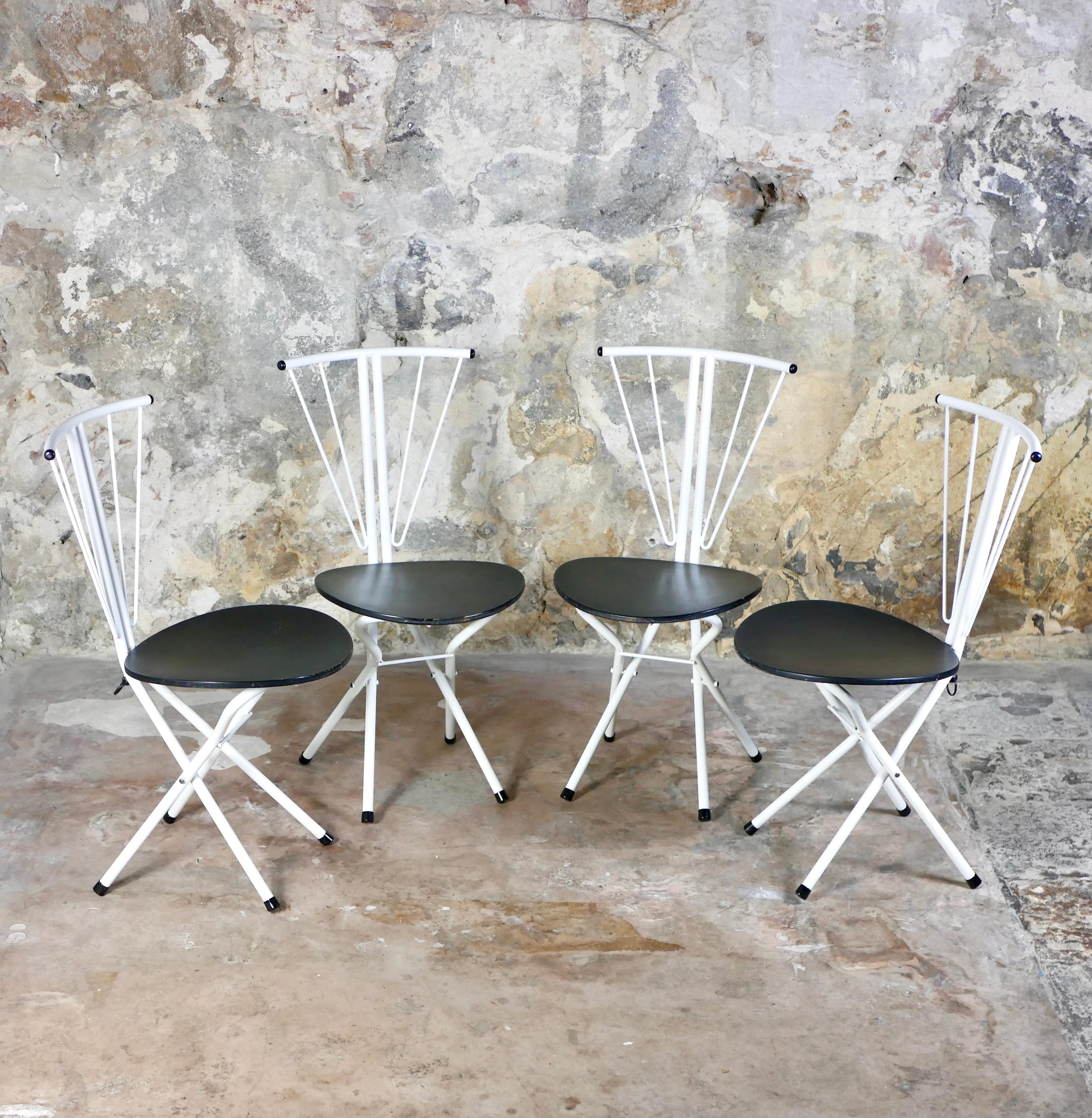 Beautiful set of 4 postmodernist folding chairs from the 1980s, in white lacquered metal and black lacquered wood in the style of the Memphis Group.
A ring in the back of the chair allows to fold them easily by pulling it up.
Overall good condition,