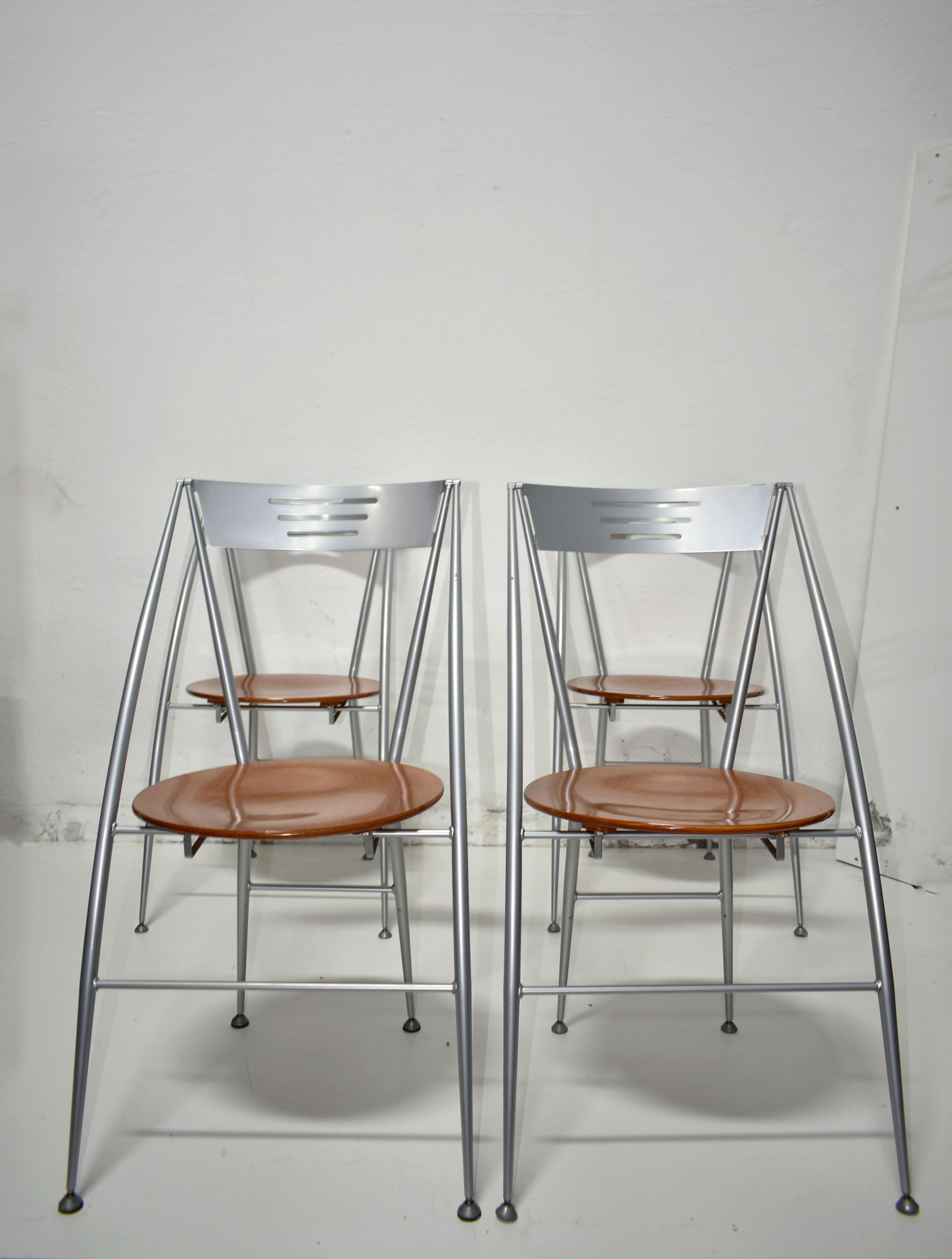 Set of 4 Italian designer folding dining chairs produced in the 1980s by Calligaris

Very elegant Postmodern design, the round-shaped seat is made of cherrywood, the frame is made of aluminium

The condition of the chairs is very good vintage