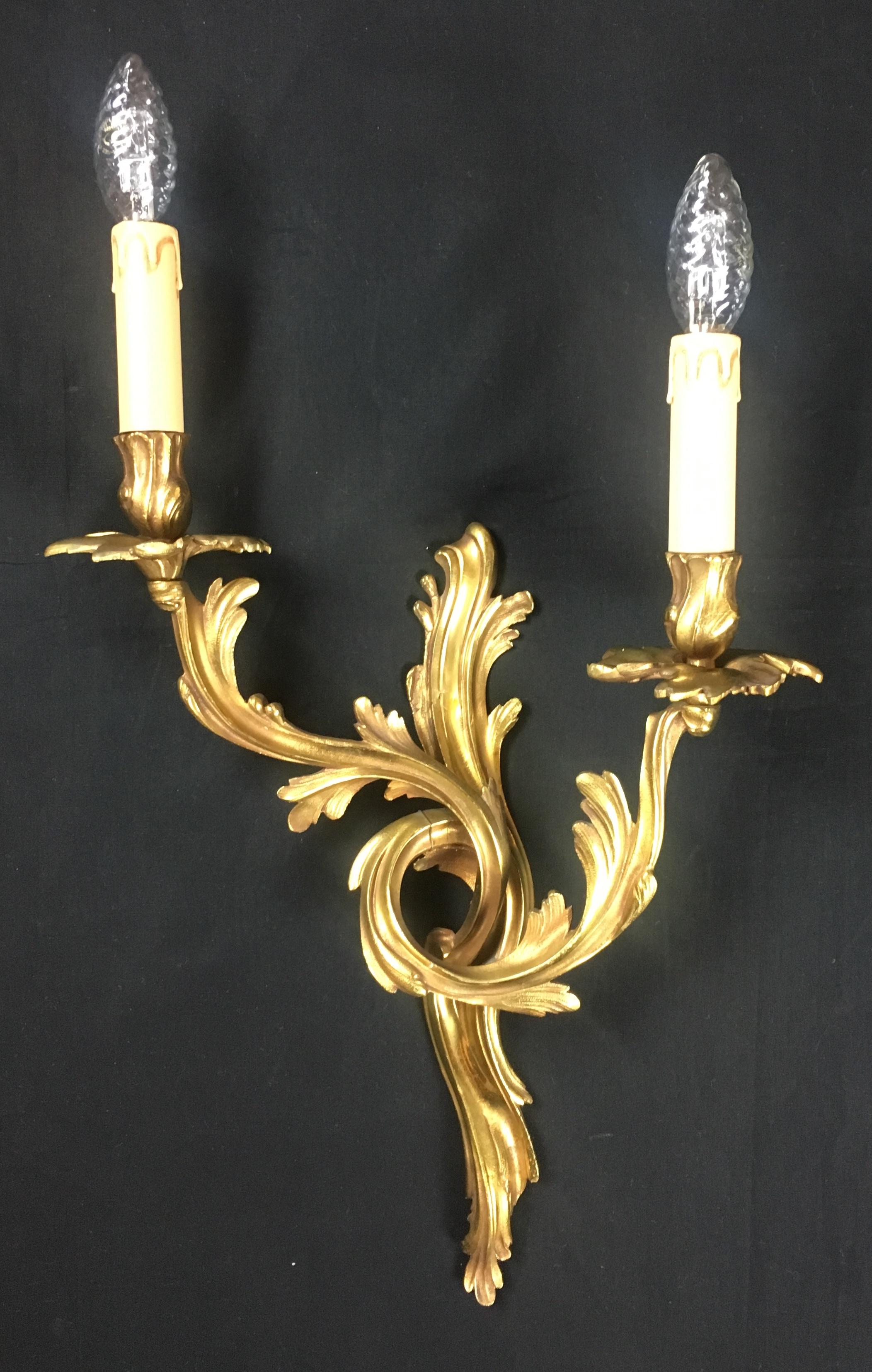 Set of 4 French Louis XV style gilded bronze double arm wall sconces, in very good condition. Very decorative floral and leaf tiered scrolling arms. 

Very nice quality and very well cast.
  