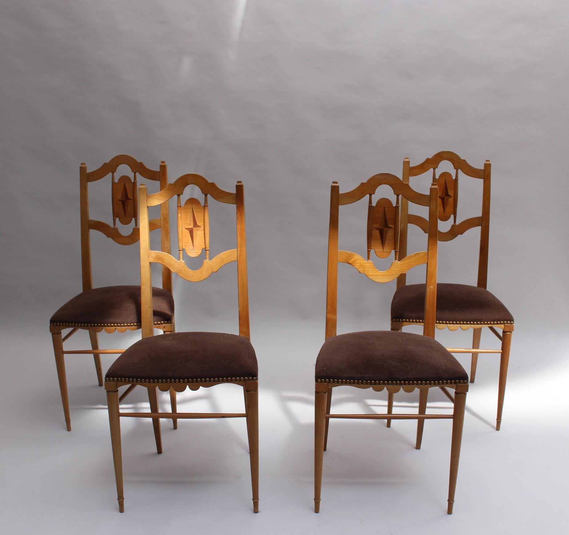 A set of four French 20s-30s cherry wood chairs with openwork backs and geometrical inlaid marquetry with a carved base and tapered legs.
Stamped on two chairs.