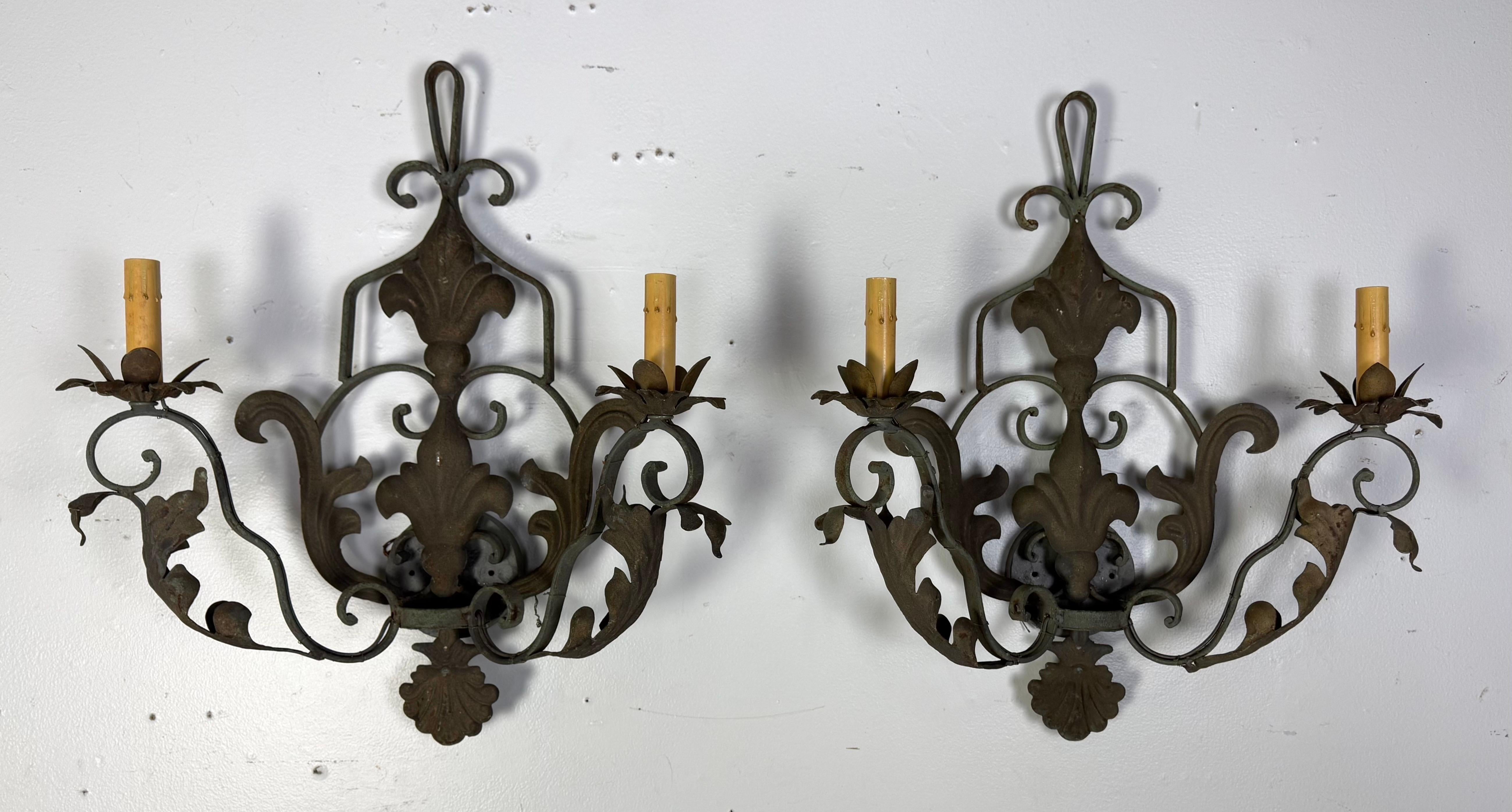 Set di quattro applique a 2 luci in ferro battuto in stile barocco francese. Ogni applique presenta intricati motivi a volute, foglie d'acanto e curve eleganti che contribuiscono al suo aspetto ornato e decorativo.

Ogni applique ospita due luci a