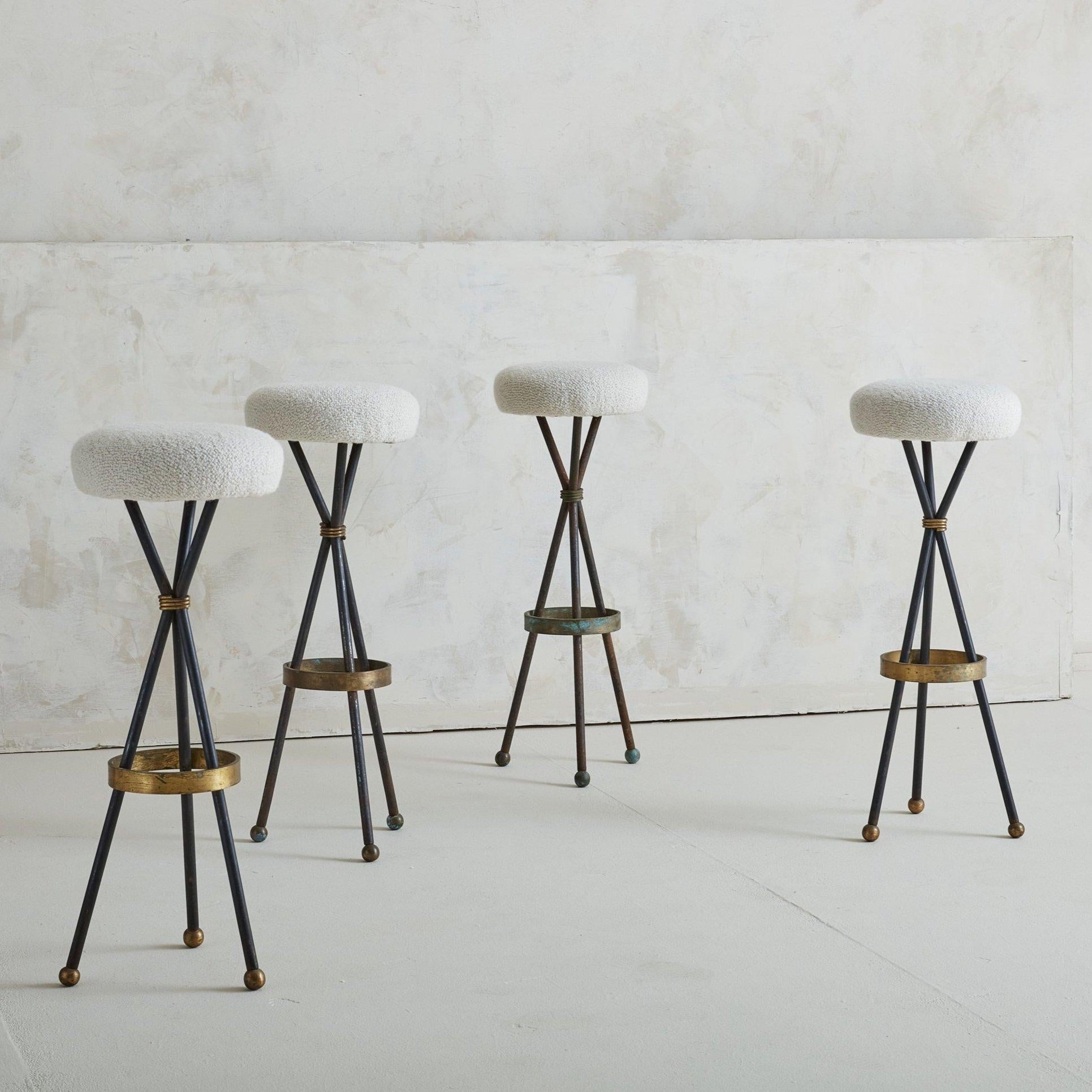 A set of four bistro stools sourced in the South of France. We were delighted to find a full set with such a gorgeous base. The tripod base is made of iron and features a patinated brass ring around the base and brass ball feet. The cushions have