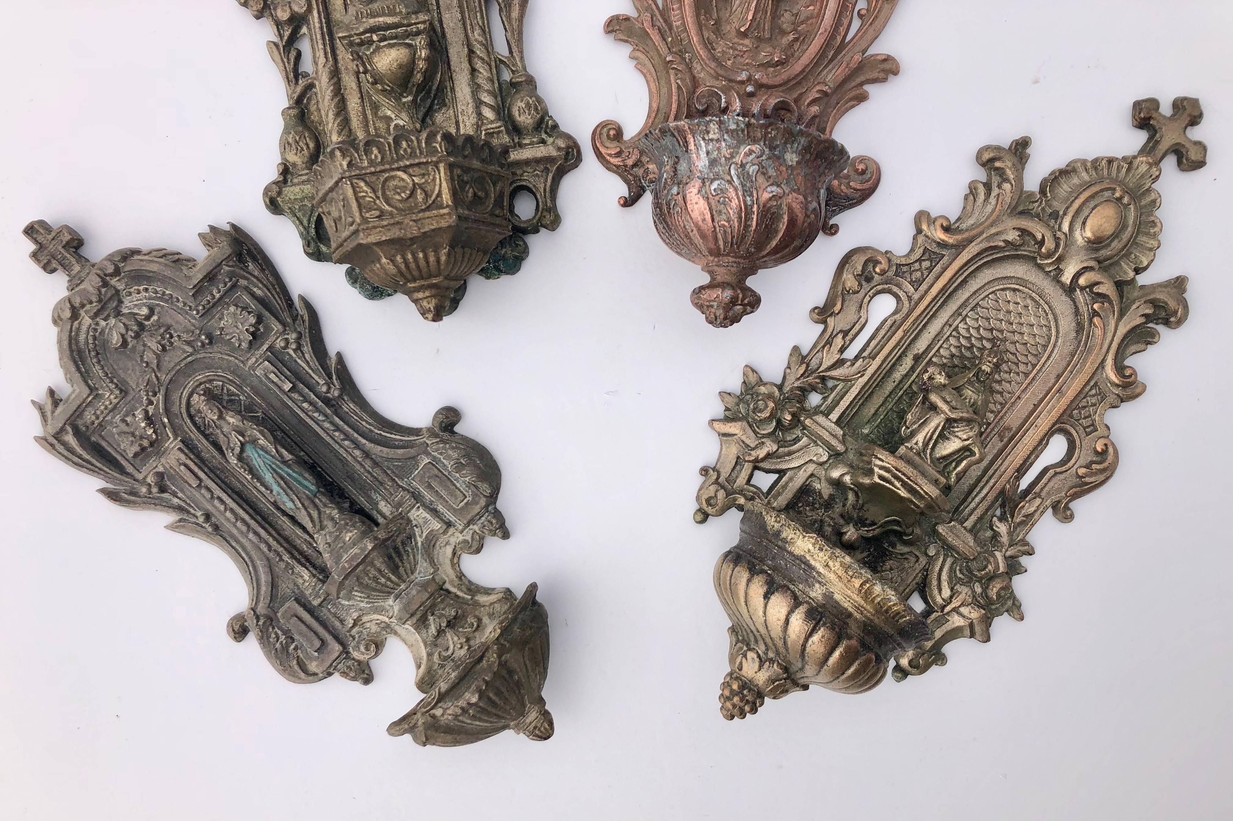 These beautiful French cast metal holy water fonts are all from the 1800s. Three of the benitiers feature Mary distributing graces while the fourth depicts Mary as 