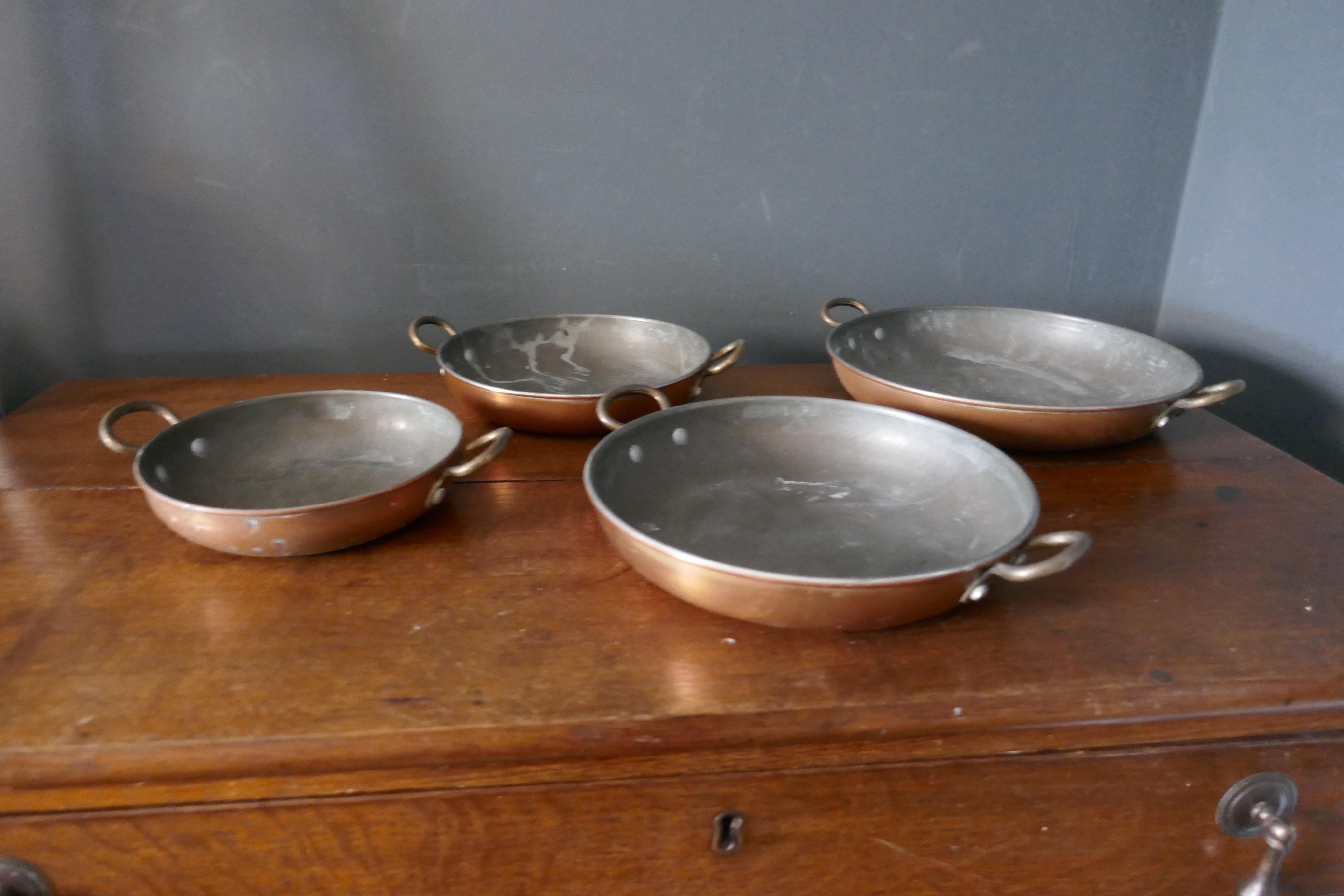 Set of 4 French copper skillet, grattan dishes

A very useful and decorative set of French copper grattan dishes
The skillets are made in copper which has been tinned on the inside and they each have 2 riveted brass handles
The dishes are all in