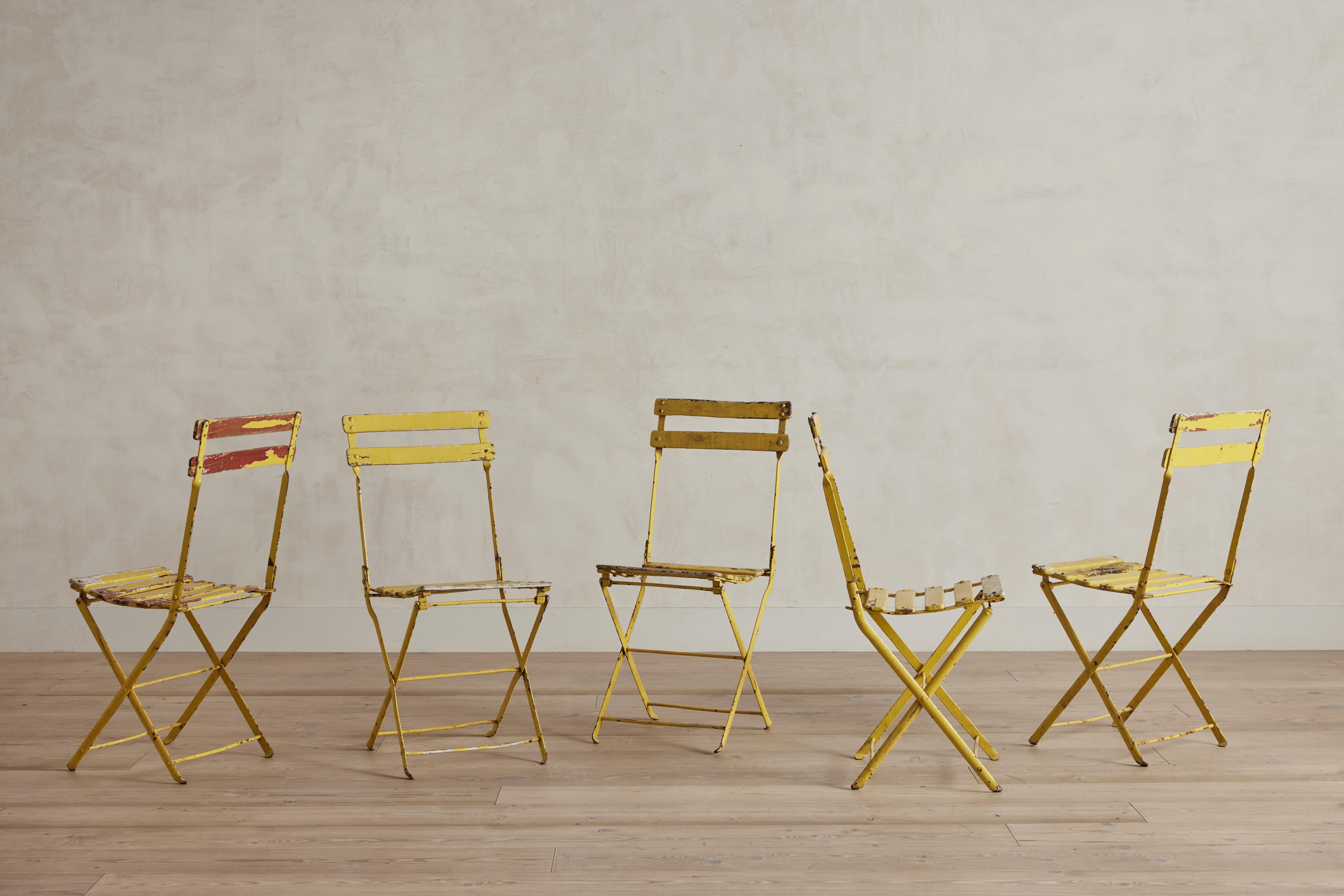 Set of five yellow painted garden chairs from France circa 1950. Made of wood and metal. Wear throughout is consistent with age and use. 