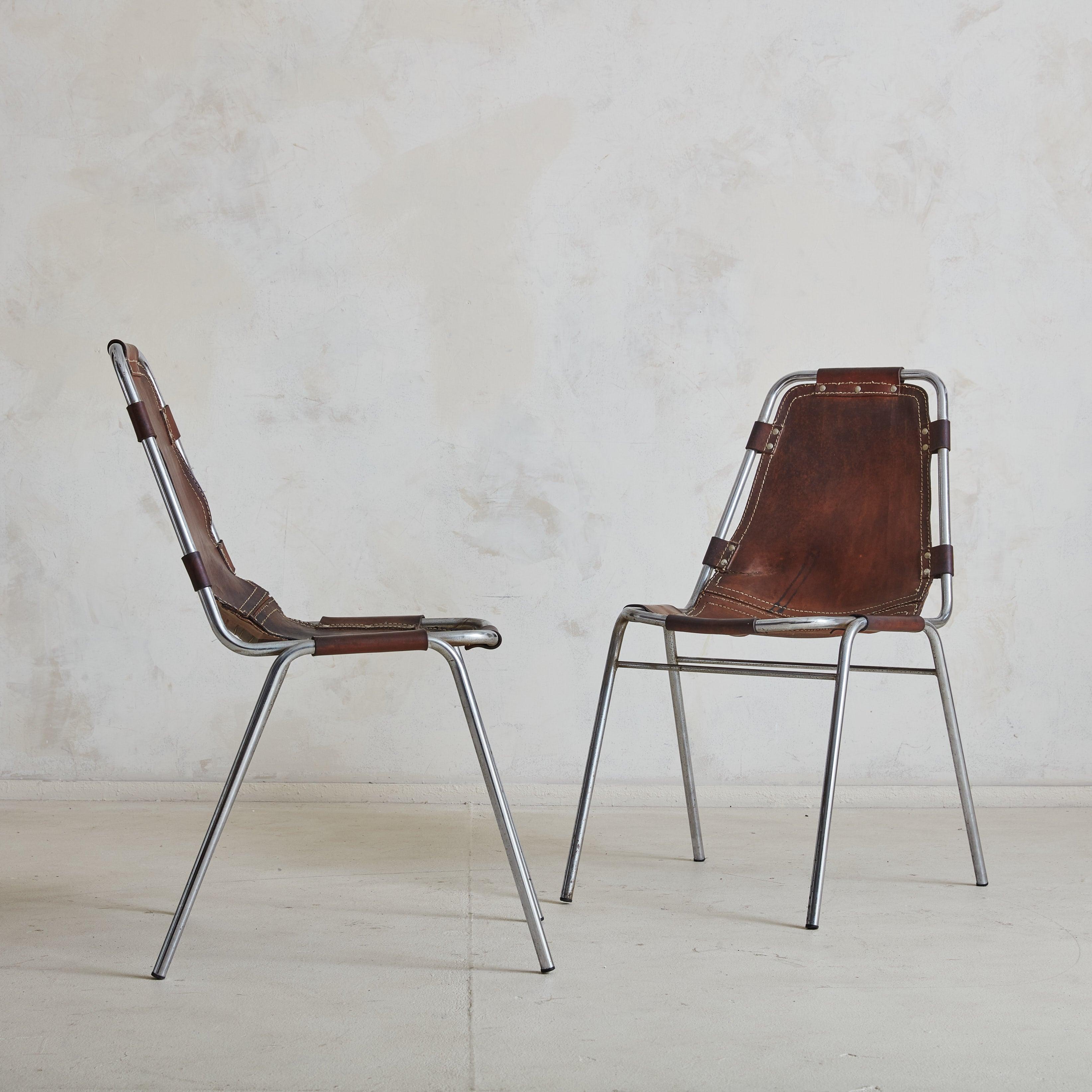 A set of four ‘Les Arcs’ chairs attributed to French architect Charlotte Perriand. Designed in the 1970s, these chairs feature tubular chrome frames with stitched chocolate leather seats and backs, which attach to the frames with leather straps and