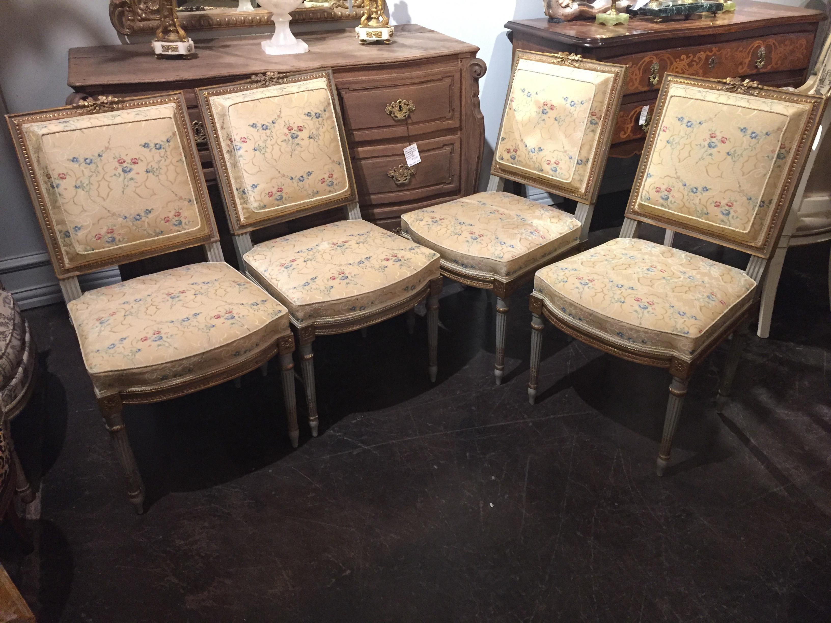 Very fine set of 4 hand carved Louis XVI style side chairs. They are upholstered in yellow floral silk fabric on the front of the chairs and the back of the chairs has a yellow and sage green plaid silk fabric. The wood is painted in a sage green