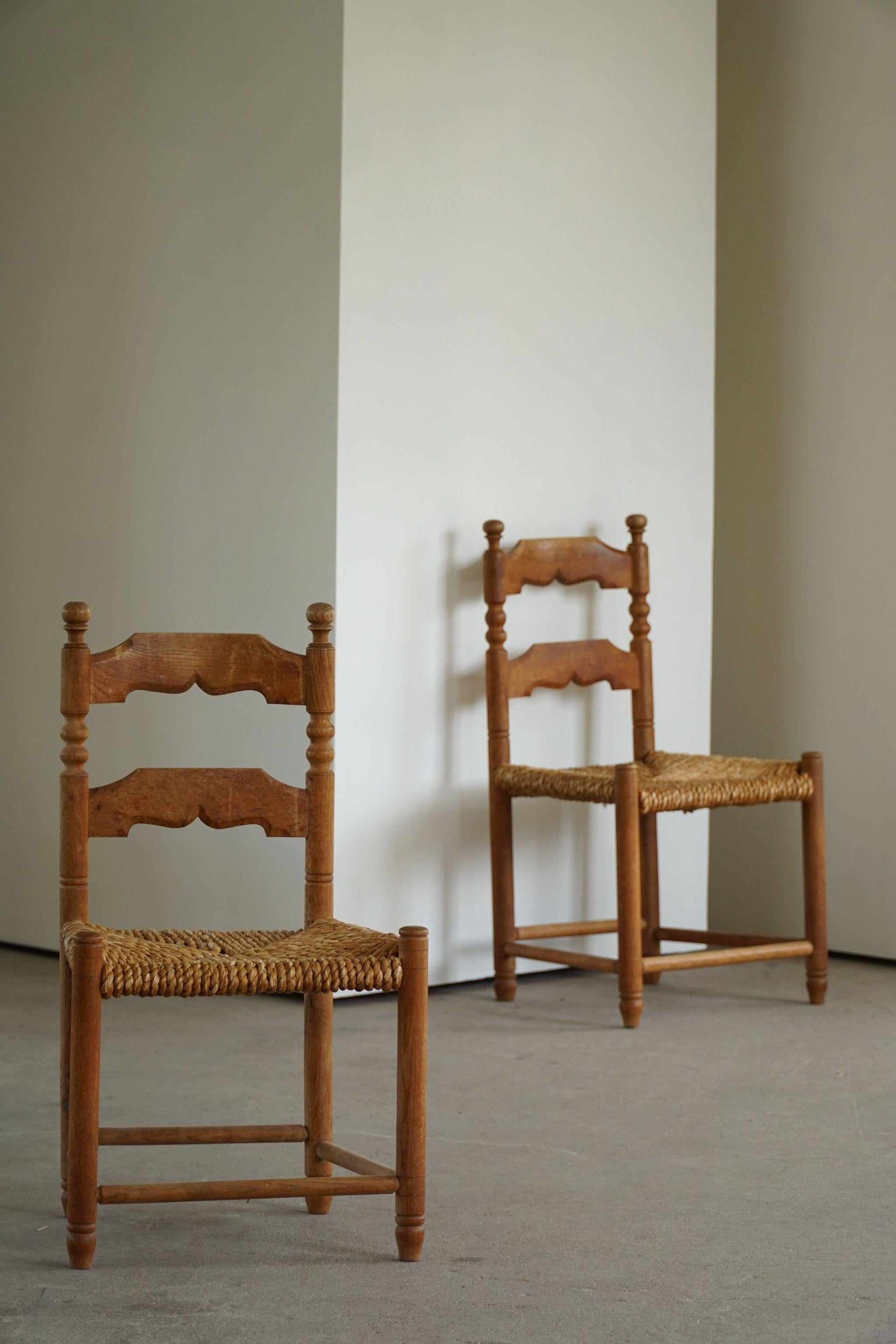 Set of 4 brutalist dining chairs in solid oak & hand woven seats of seagrass. Made by a French cabinetmaker in 1950s. A great sculptural design that match many interior styles. 

These chairs are in a good vintage condition.