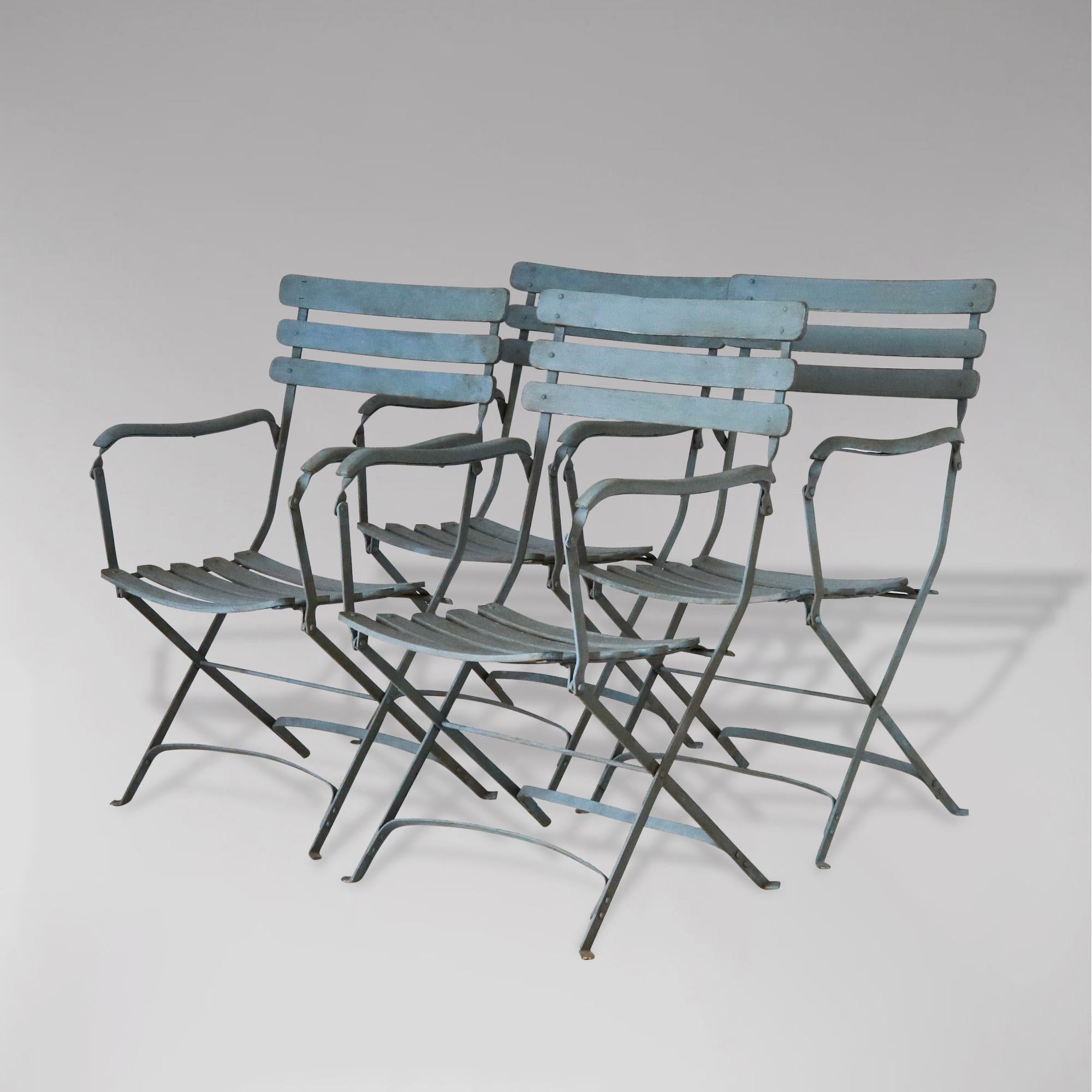 A set of 4 large French painted iron and wood folding garden armchairs. These antique wide armchairs were crafted in Normandy, France, circa 1920. Each chair has a three-ladder back and five-slat seat, and features a folding mechanism for ultimate