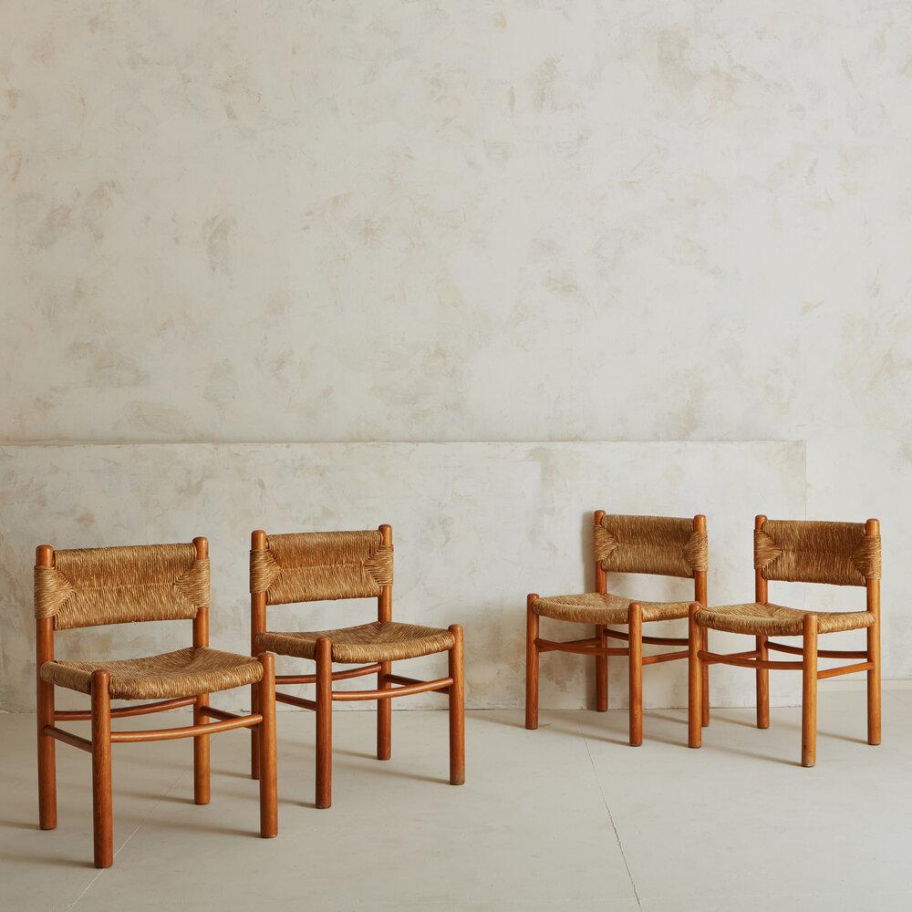 A set of four thoughtfully crafted wood & rush dining chairs, reminiscent of Charlotte Perriand and her infamous Dordogne chair for Robert Sentou. Sourced in France, 1950s. 

 