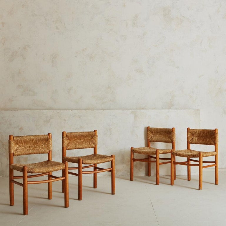 A set of four thoughtfully crafted wood & rush dining chairs, reminiscent of Charlotte Perriand and her infamous Dordogne chair for Robert Sentou. Sourced in France, 1950s. 

 