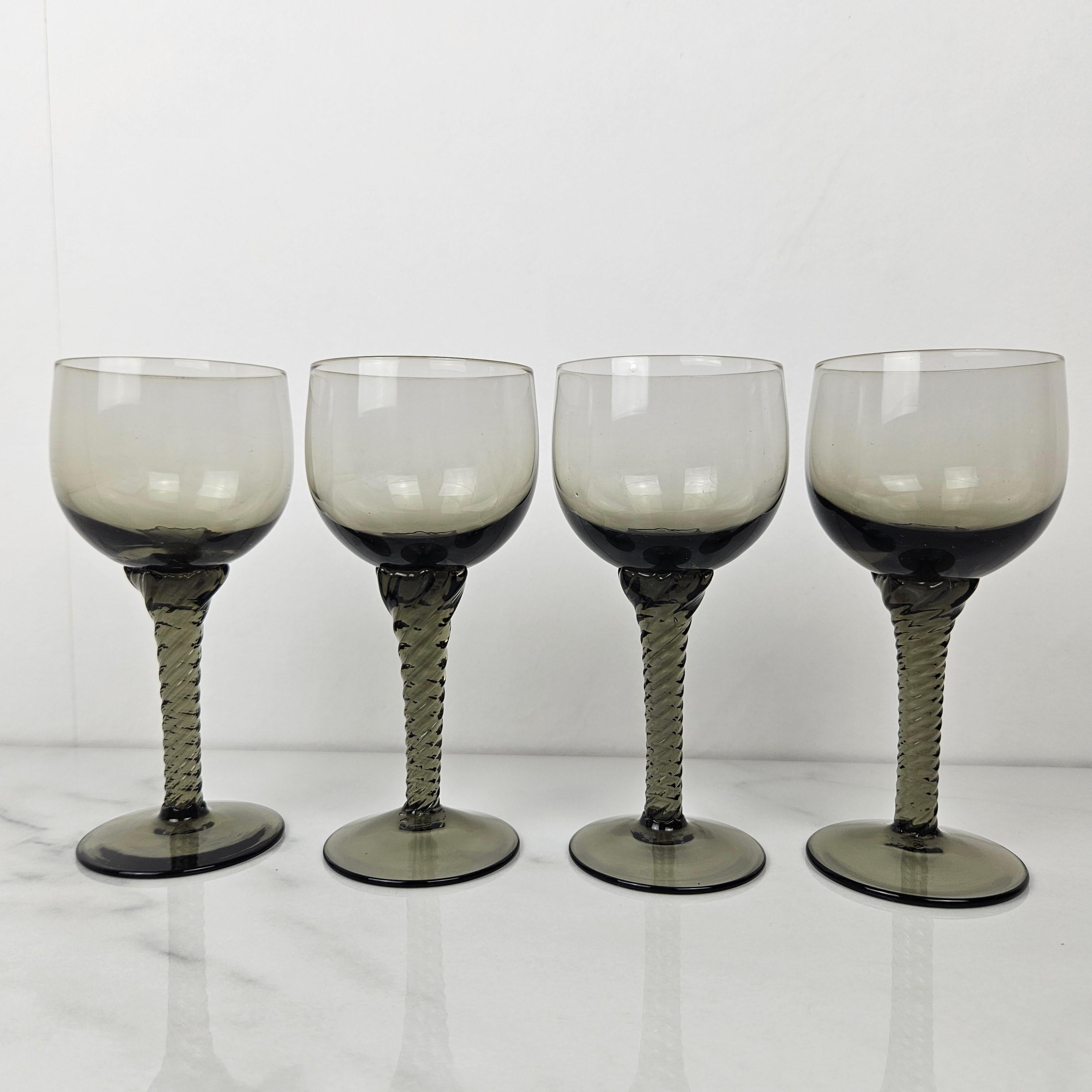 Elegant set of four hand-blown wine glasses made in France, dating from the 1930s. 
Each glass features a beautiful smoky gray hue with a subtle gradient and a finely twisted stem — a true example of French craftsmanship from the early 20th