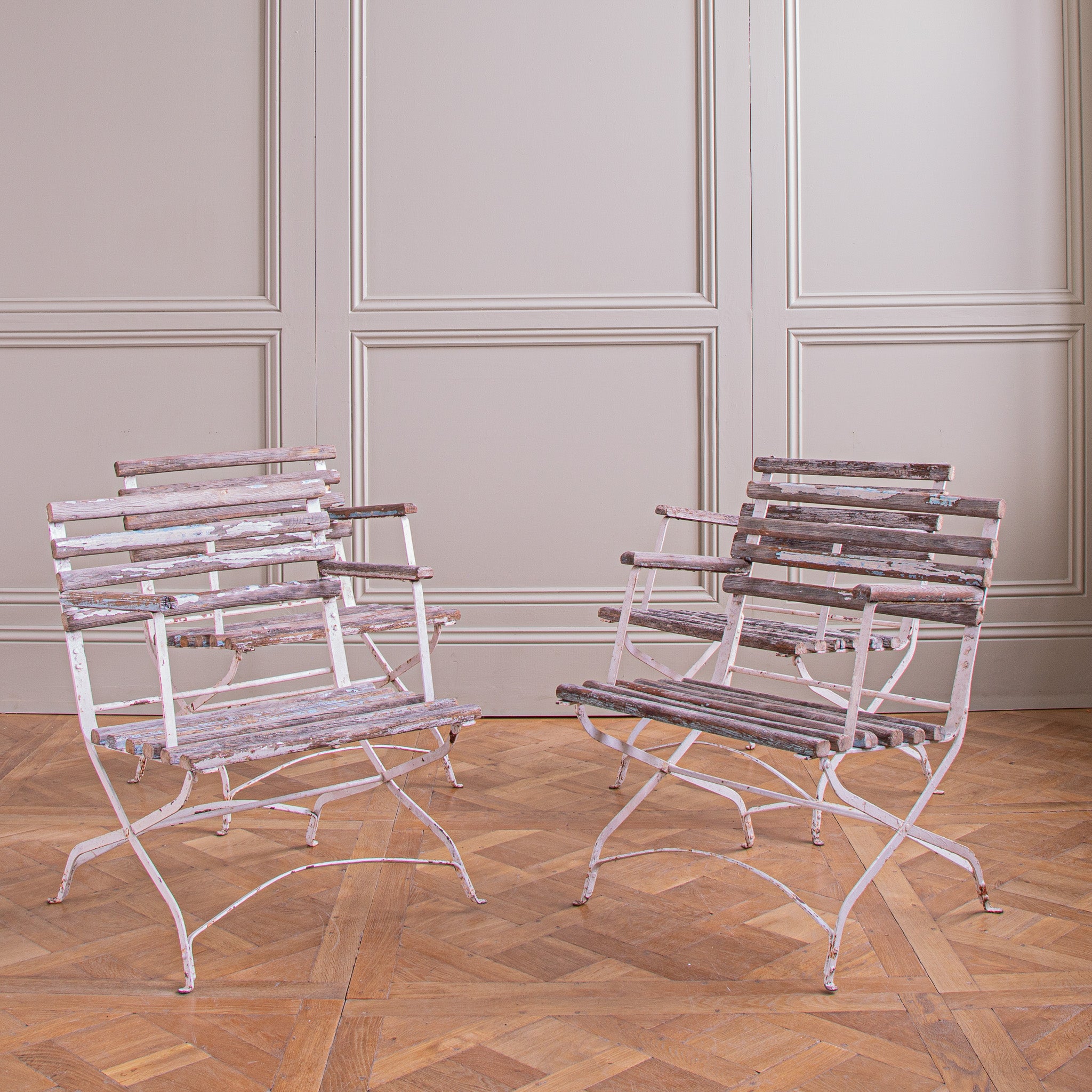 A  set of 4 slatted wood, garden armchairs from the South of France,. The chairs feature a generous seat size made with metal frames which have beech wood, cross slats . Once painted white and later blue, small amounts of both these colours can