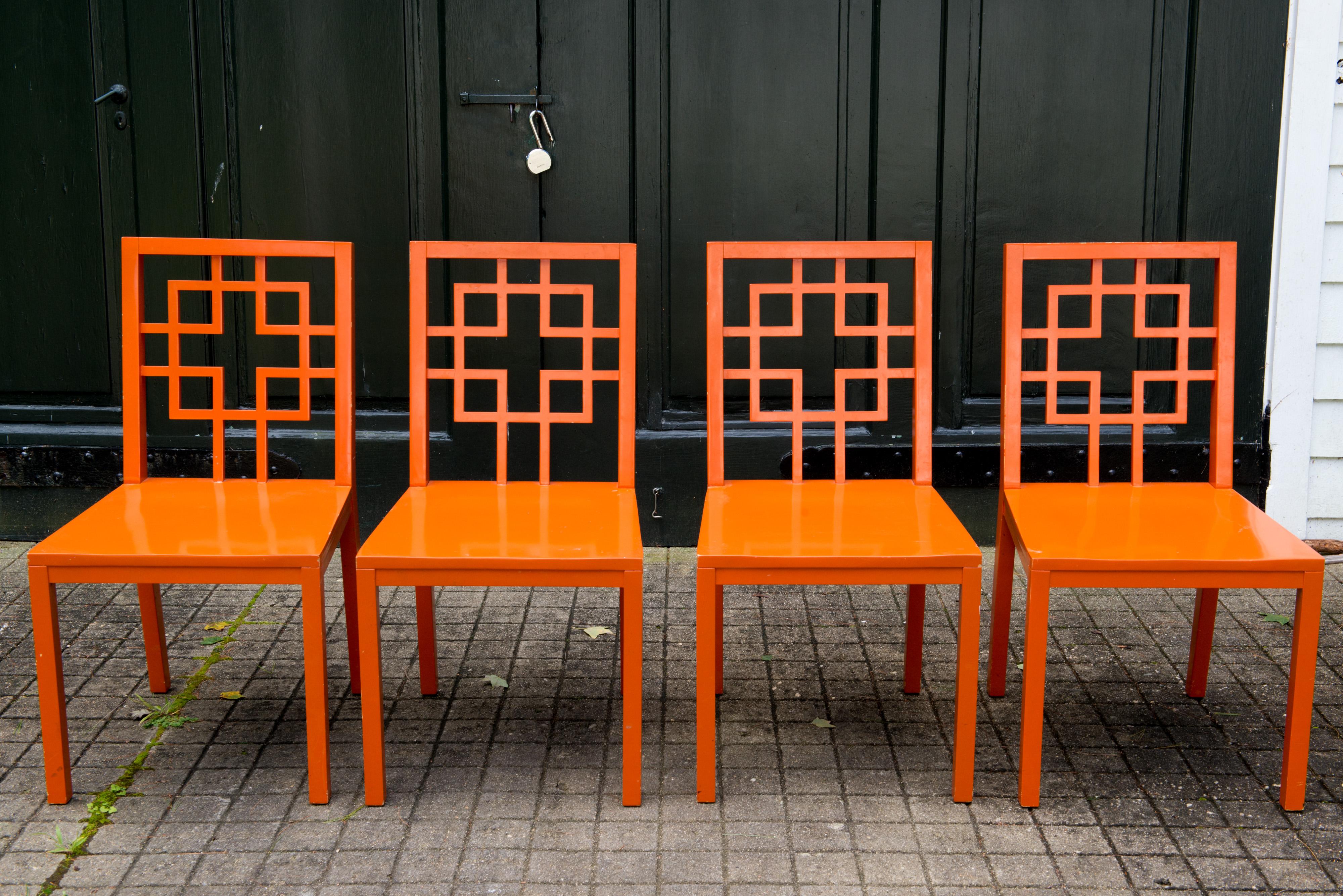 Set of 4 stylish fretwork chairs, orange lacquer over wood. Side chairs.
