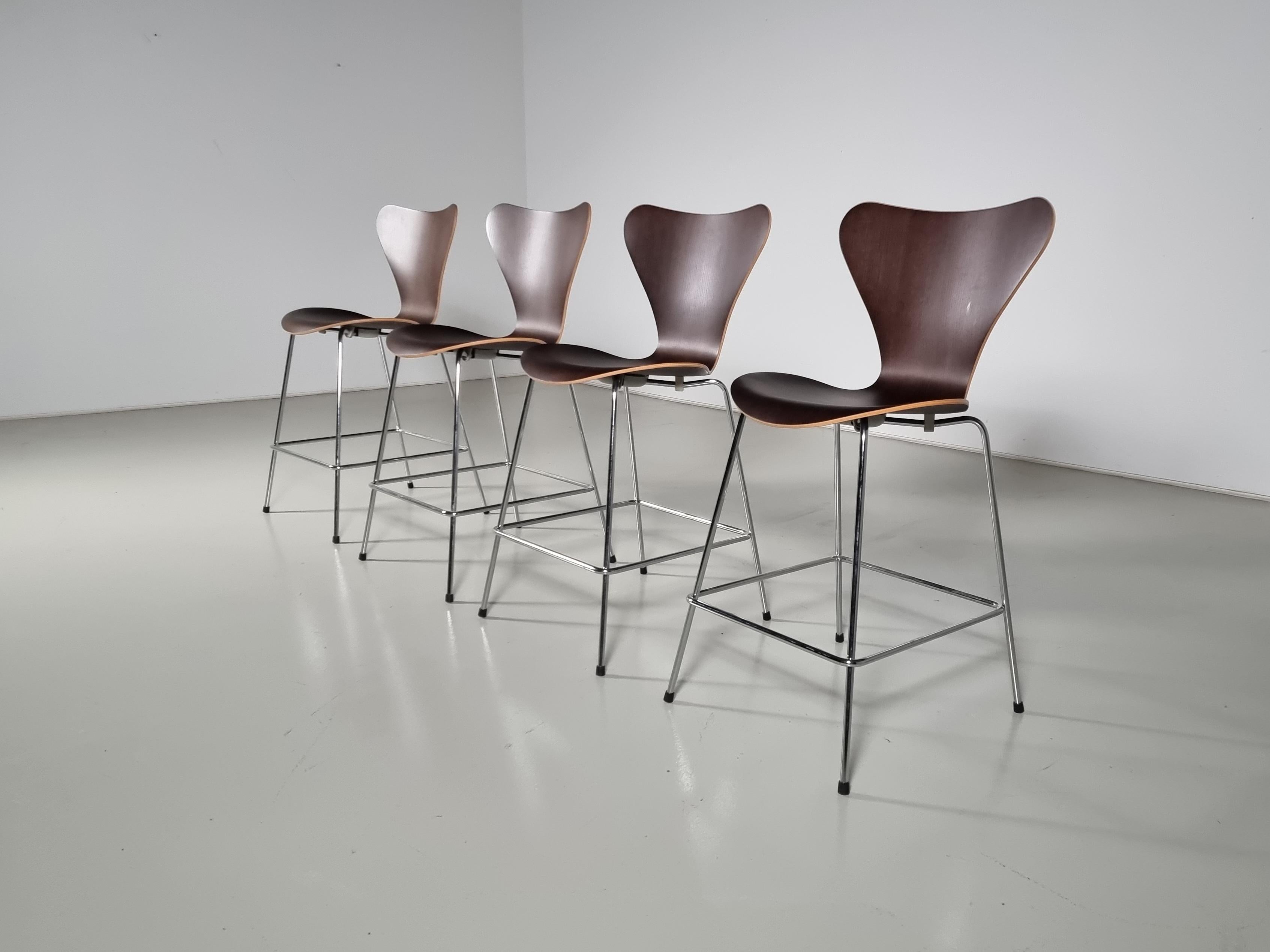The Fritz Hansen Series 7 Bar Stool by Arne Jacobsen, designed in 1955

The seat is made of curved dark stained oak plywood, a technique he previously used in the Ant Chair. The series 7 Butterfly is seen as the crowning achievement of Arne