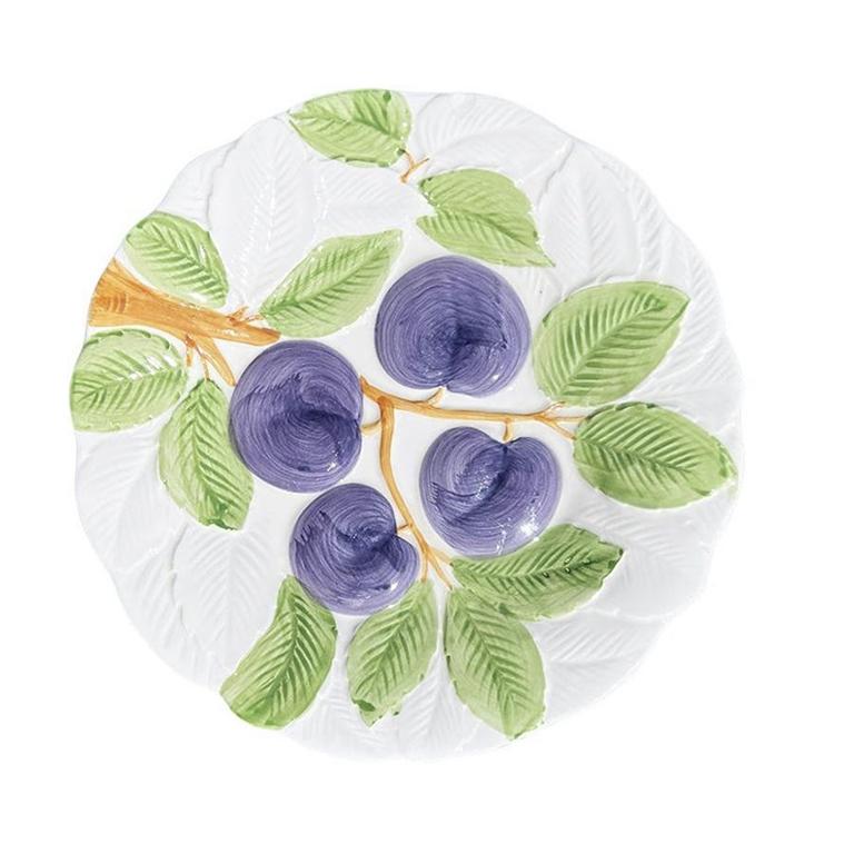 A set of four ceramic Fruit du Jour plates by Shafford. This set was created in 1987 and features hand-painted fruits at the center of each. The fruits include grapes in purple and green, peppers in yellow and green, plums in purple and green, and