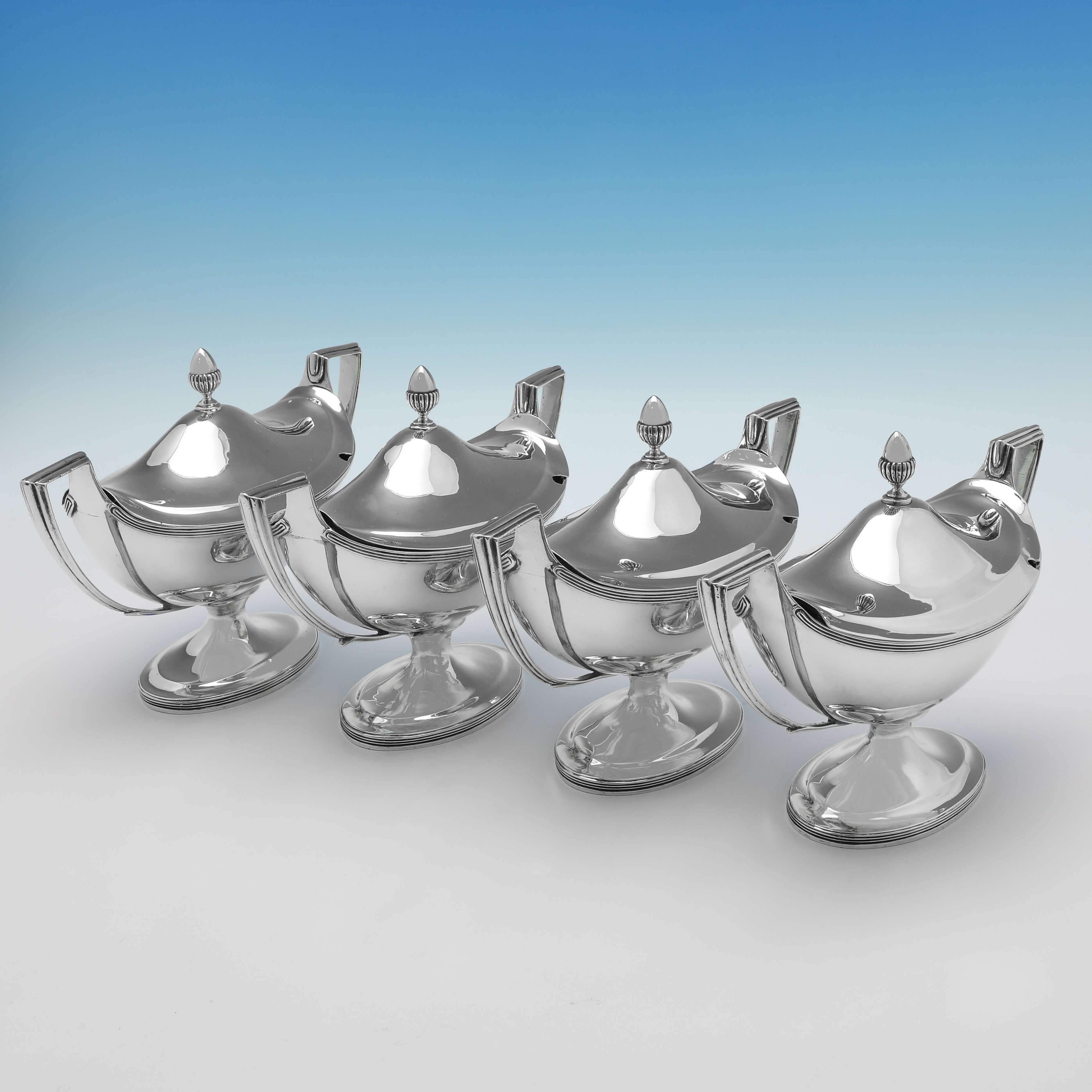 Hallmarked in London in 1802 & 1803 by John Emes, this handsome set of 4, George III, Antique sterling silver sauce tureens, are 'Boat' shaped, and plain in design, featuring reed borders and acorn finials. Each sauce tureen measures 6