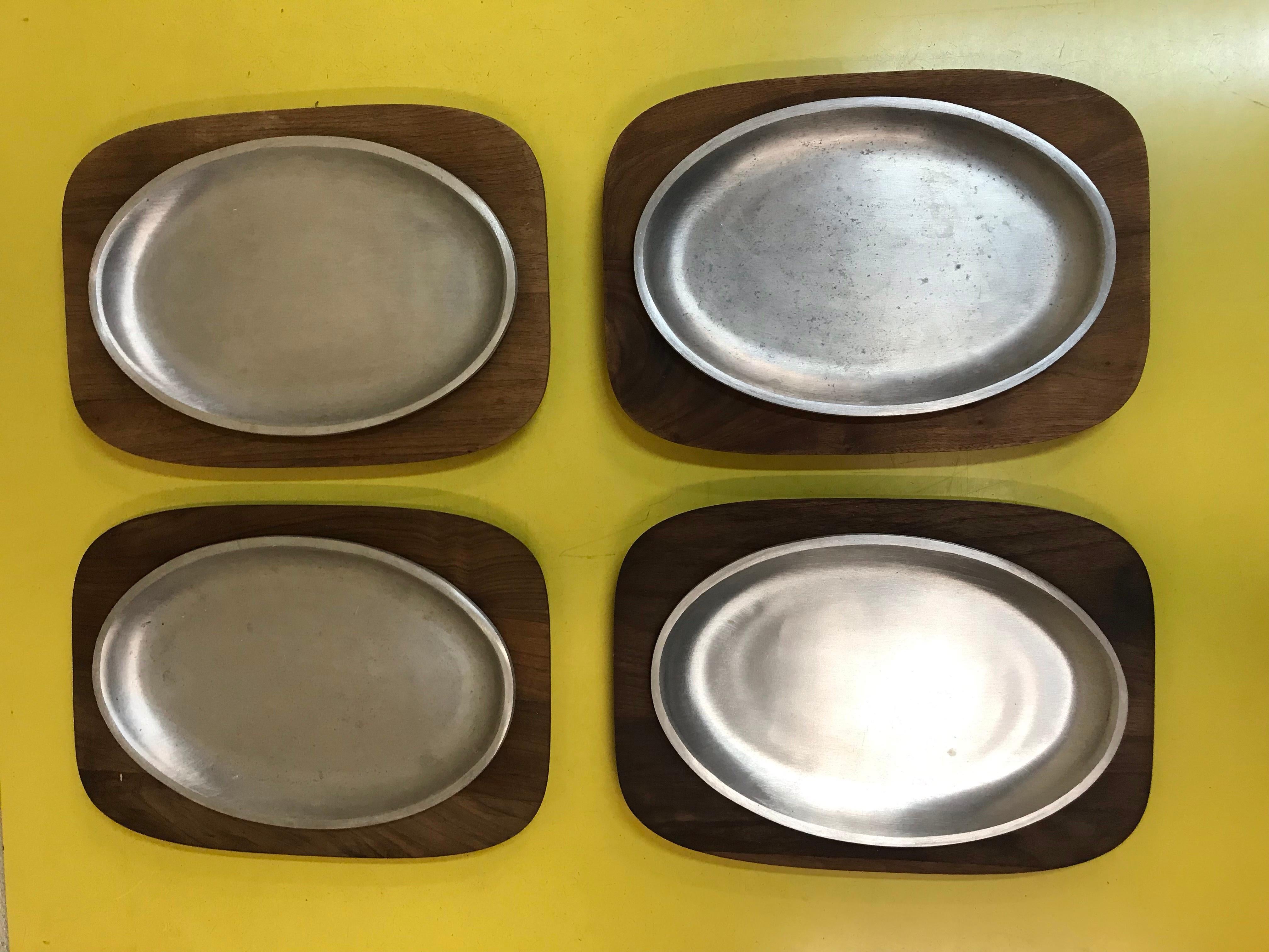 Rare set of 4 teak charger plates and the sizzling aluminum plates. Chargers 12 inches width diagonal they are 13 1/2 inches. Sizzle plates are almost 9 3/4 inches. No splits, cracks or repairs.
  