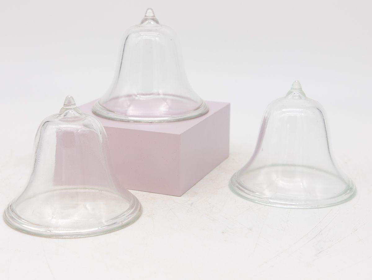 A set of four mini glass cloches. Ideal table top or bookshelf size. French midcentury. Wear consistent with age and use. Multiple sets available.