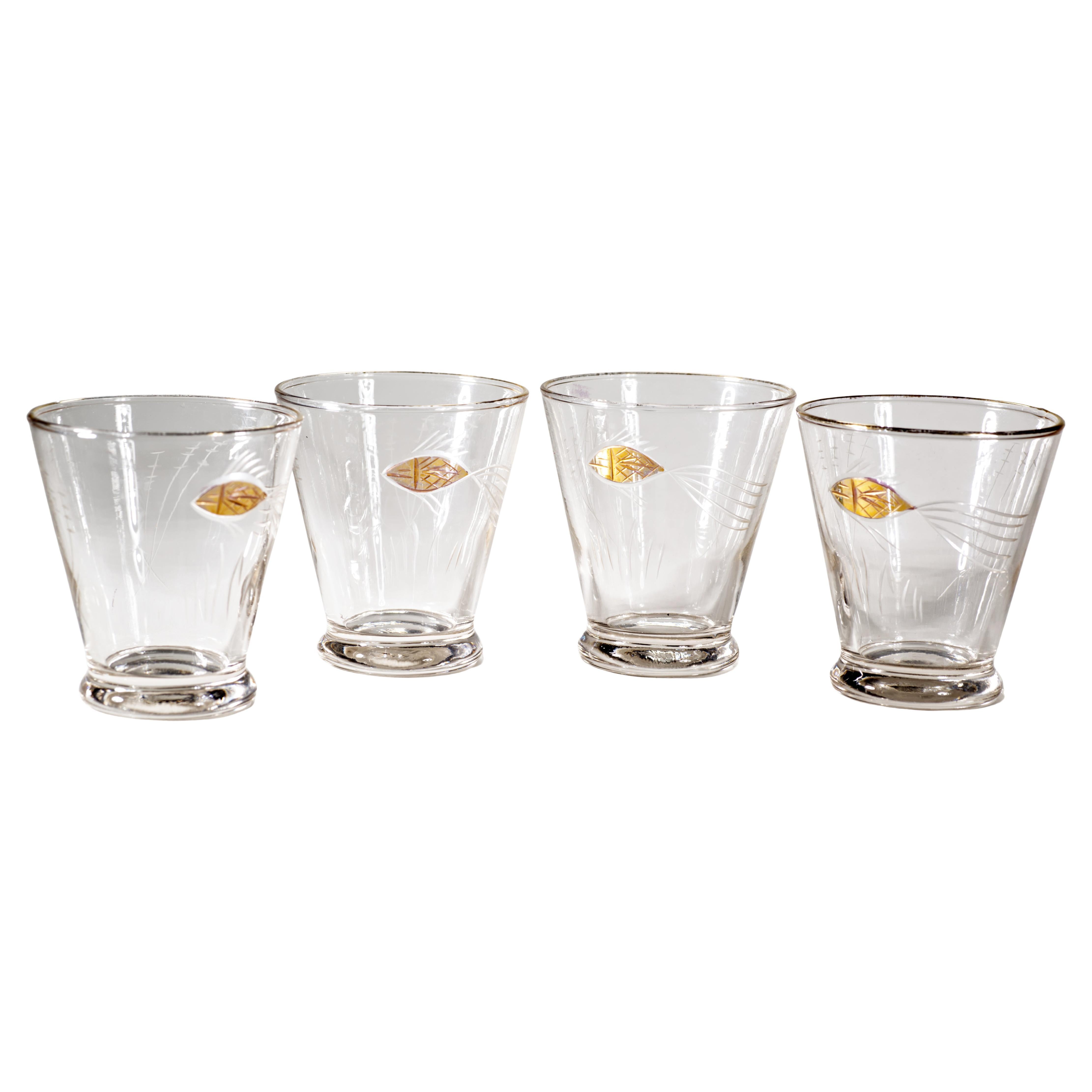 Raro e inusual juego de 4 vasos con decoración grabada de peces nadando en el mar entre vegetación abstracta, con detalles dorados aplicados y borde dorado. La decoración es similar a los diseños modernos escandinavos de los años 30-50, como el