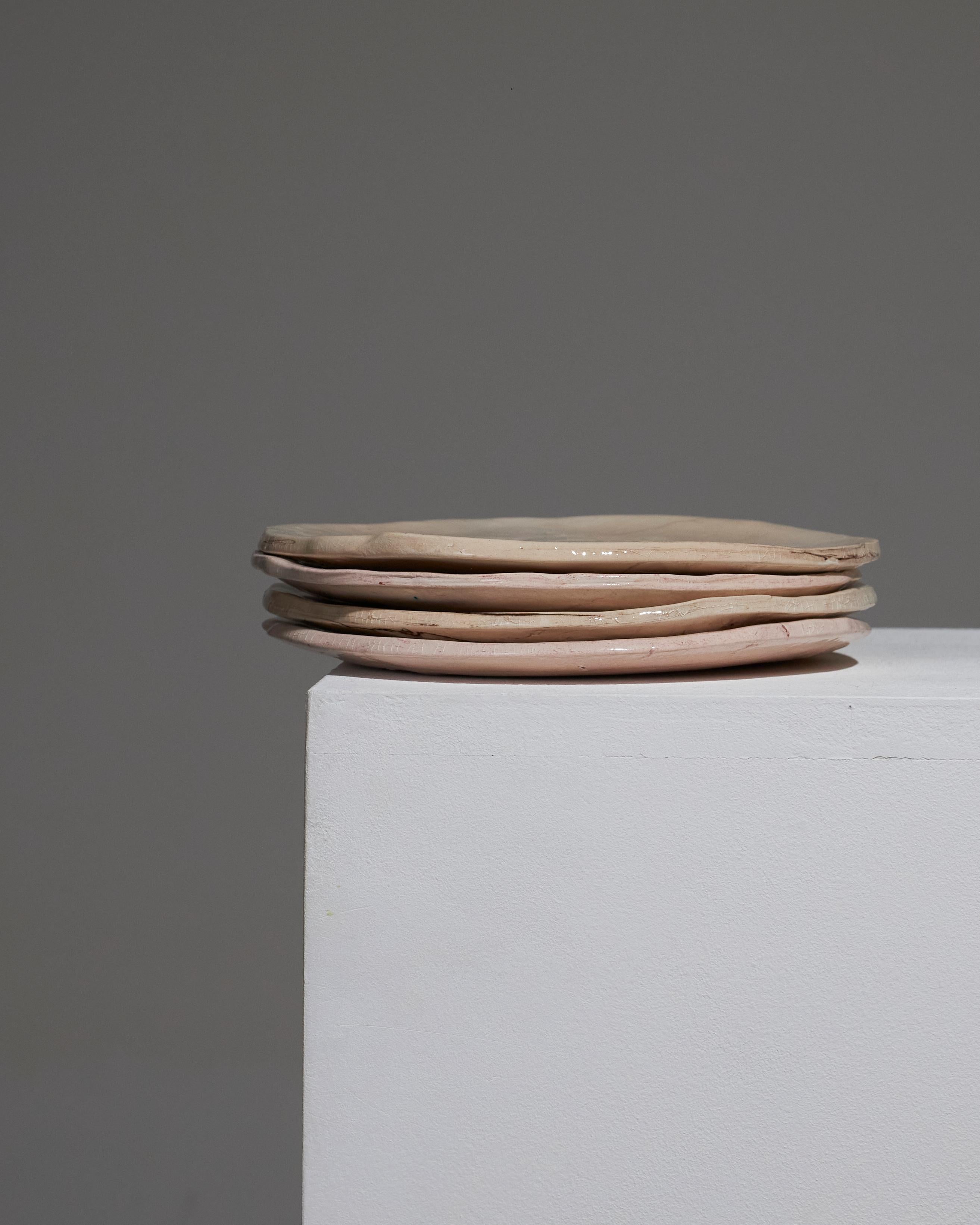 Ensemble de 4 assiettes à dessert ou à entrée en céramique émaillée beige à effet marbré, par l'artiste Suzie Lapierre d'Artistics. Des pièces uniques aux motifs et finitions variés, mettant en valeur la nature artisanale de leur création. Signé au