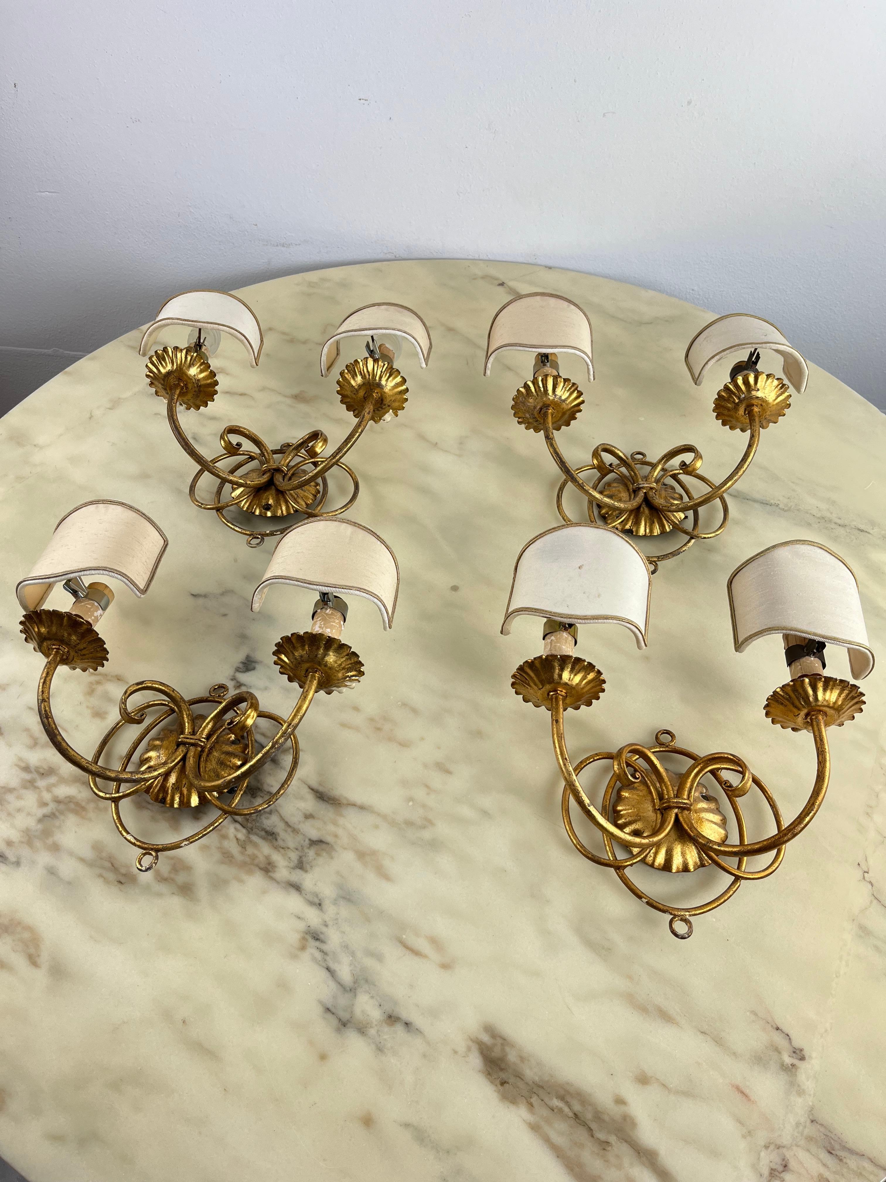 Set of 4 golden wrought iron wall lights, 80s Italian design
Handcrafted by the Li Puma company of Florence. Each has two e14 lamps equipped with small fabric shades.
Intact and functioning.
Good condition, small signs of aging.