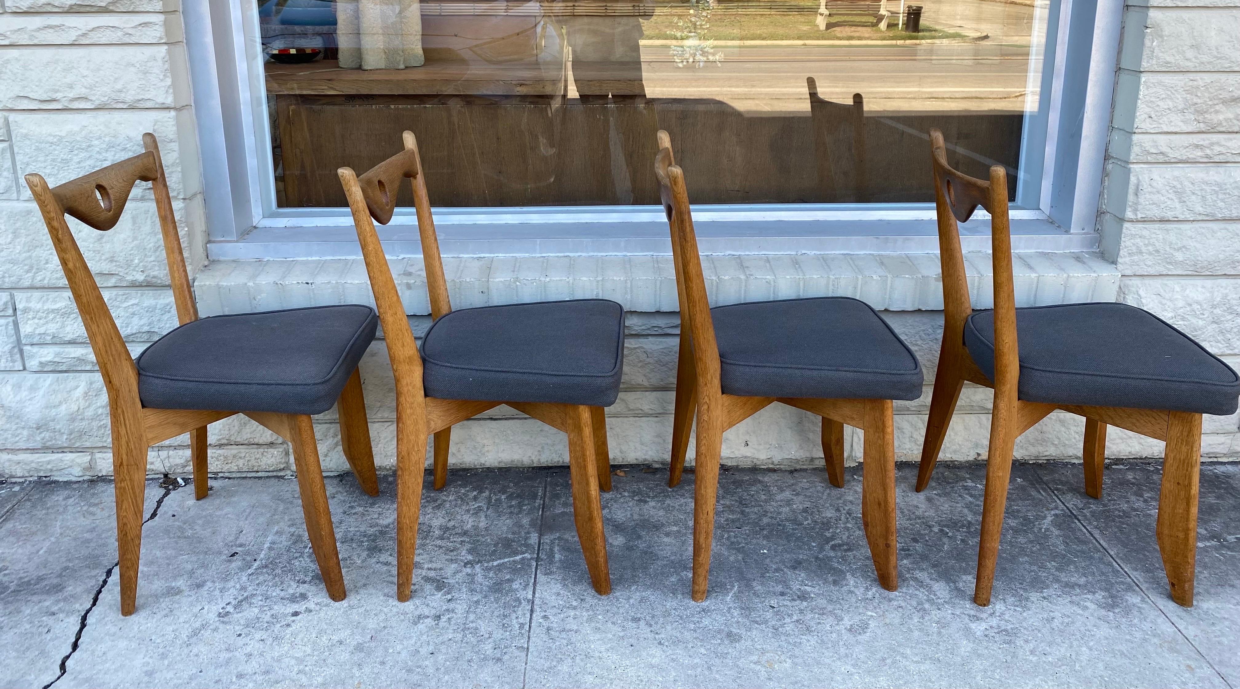 Ensemble de 4 chaises de salle à manger Guillerme et Chambron en chêne massif avec revêtement en tissu gris, circa 1960, France. 
Dimensions : 17 