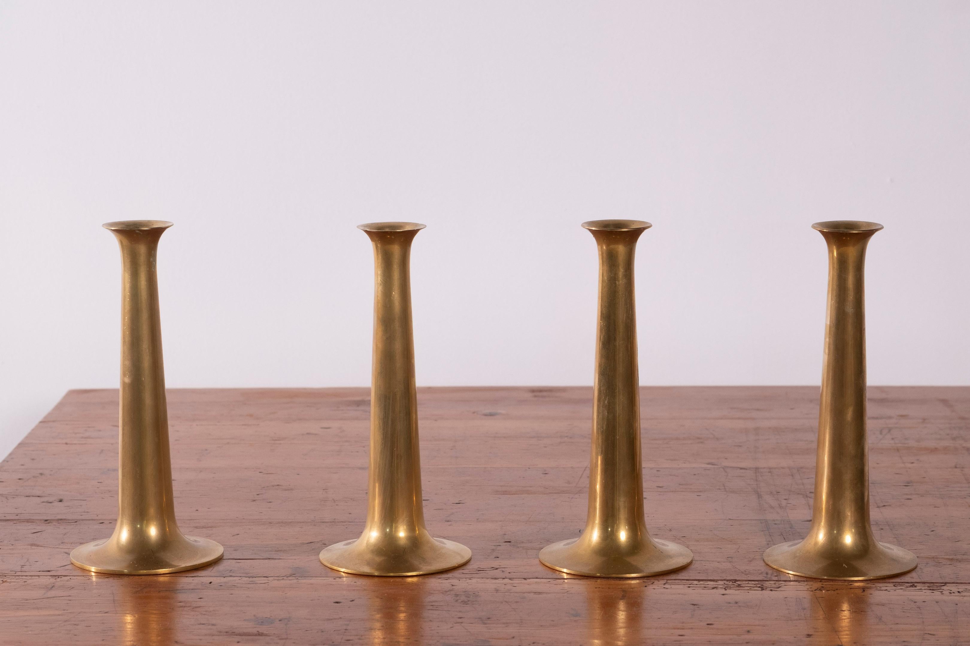 This elegant set of four candlesticks was designed in the 1950s by renowned Danish architect and designer Hans Bølling and produced by Torben Ørskov & Co., a key name in mid-century Danish design manufacturing. Crafted in polished stainless steel,