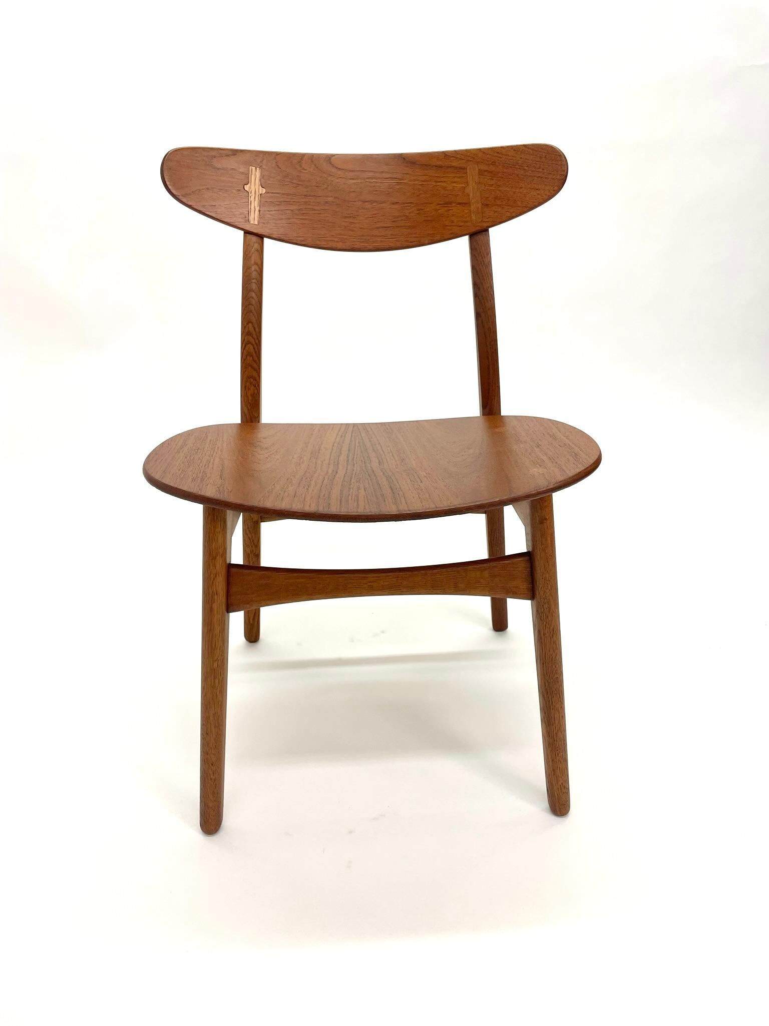 Rare set of Hans Wegner CH-30 dining chairs with wood seat. These chairs are made of Teak and Oak and feature Hans Wegner classic contrasting wood cross on the back of the chair as well contrasting wood on the seat. Pictures show the chairs before