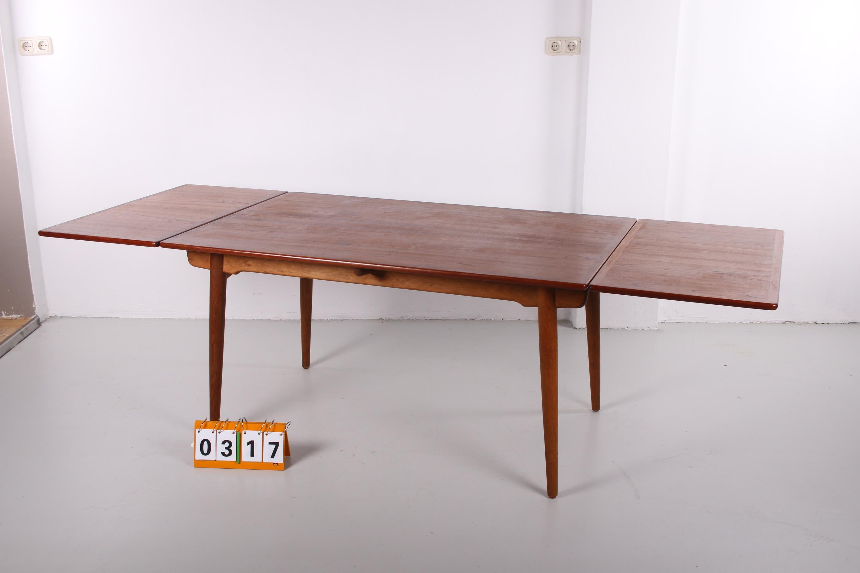 This is a beautiful rare large edition of model AT 312. A dining table designed by Hans J. Wegner, produced by Andreas Tuck in Denmark. Equipped with 2 extension leaves of 60 cm each. Legs in solid oak, table top in teak. In perfect condition.