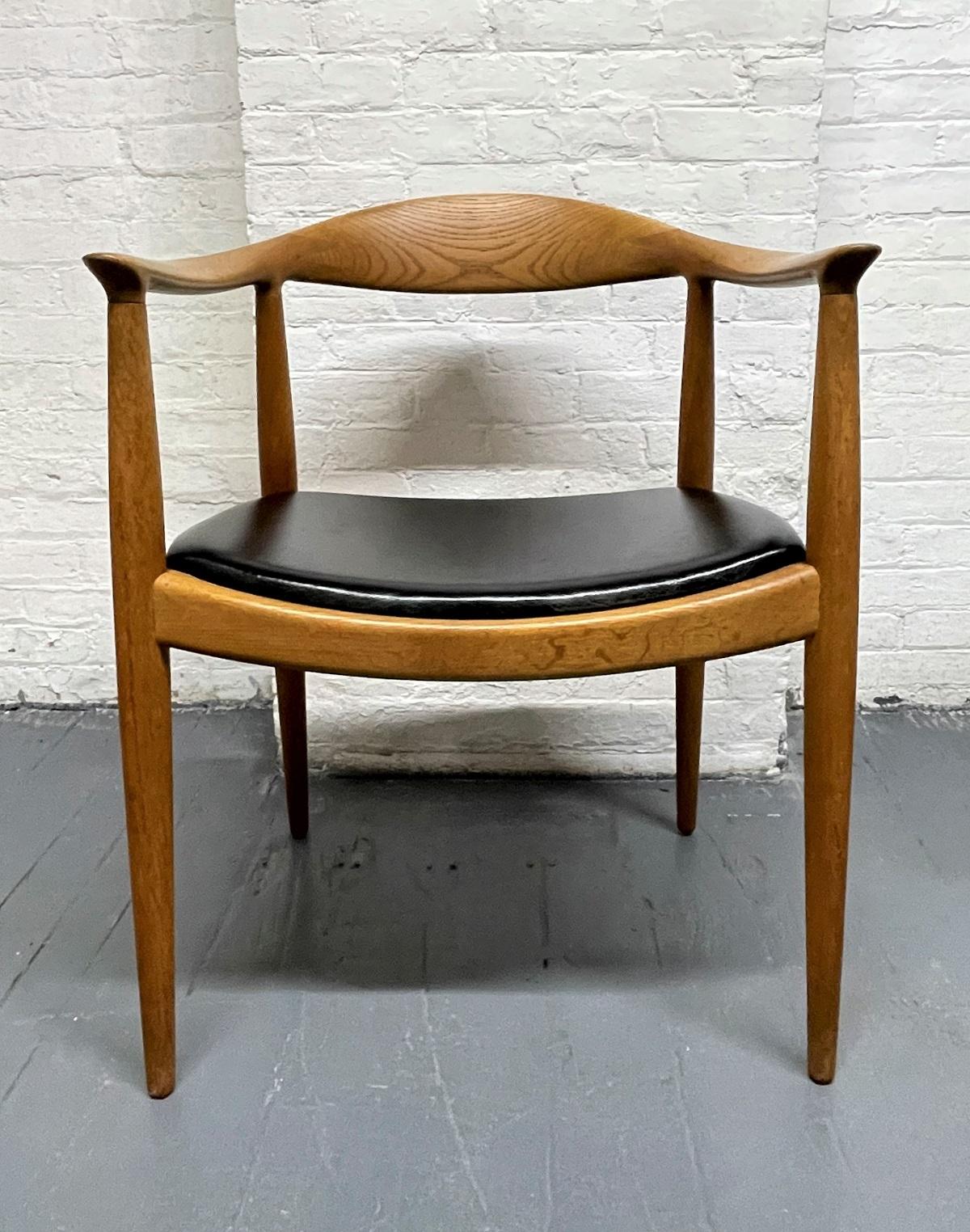 Set of 4 Hans Wegner Round Chairs for Johannes Hansen. Also known as The Chair. Each chair has curved backs constructed from oak with conforming pin shaped legs with original leather seats. Each stamped with manufacturer's mark underside of each